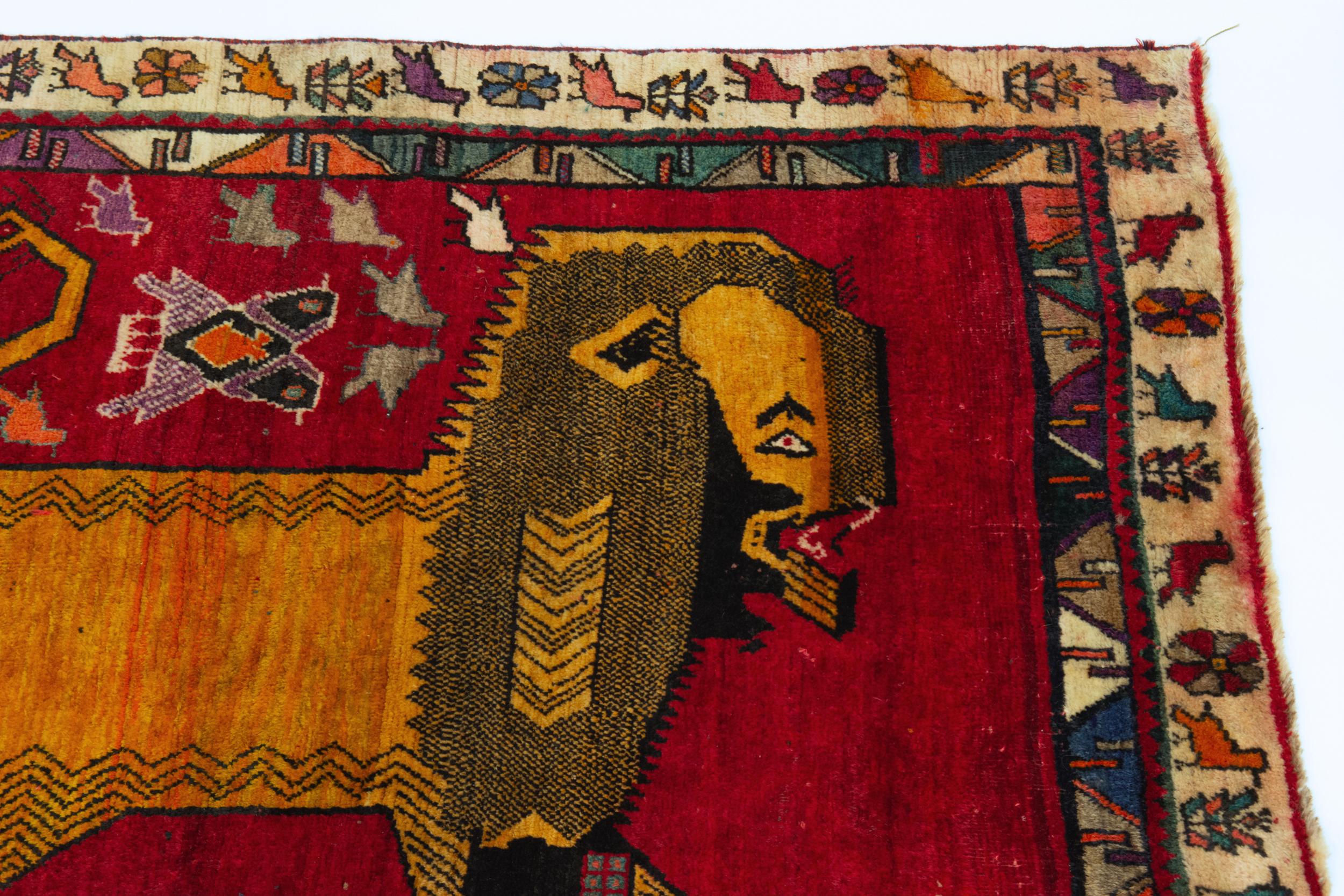 A vintage Persian hand knotted wool pile lion tribal rug. Circa 1980.

The rug is woven on a wool foundation, with a pictorial design of a large lion around birds over a ruby red field. The two borders designed with geometric pattern, tribal flowers