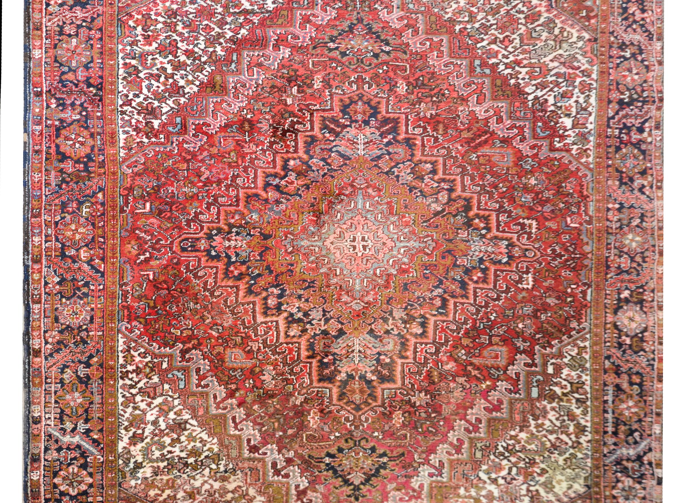 Ein wundervoller, kühner persischer Heriz-Teppich aus dem späten 20. Jahrhundert mit einem unglaublichen Rautenmedaillon, das mit unzähligen Blumenmustern in wundervollem Crimson, Creme, Rosa, Violett und Orange gewebt ist und von einer breiten,