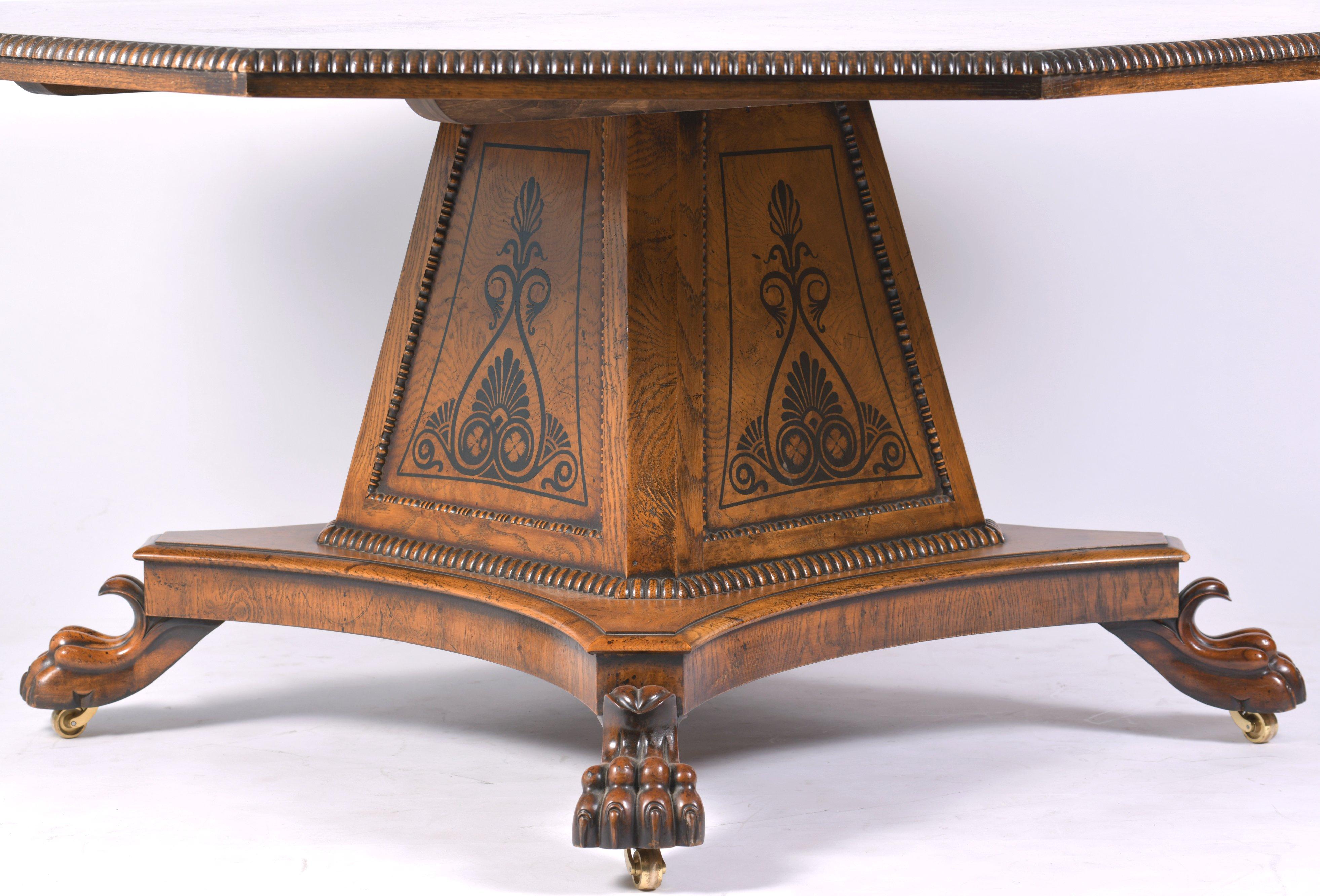 This beautiful and very stylish pollard oak octagonal dining table is in the manner of George Bullock with ebony inlay detailing. The table features a central 4 sided pedestal base with ornate paw feet on brass castors. It measures 63 in – 160 cm in