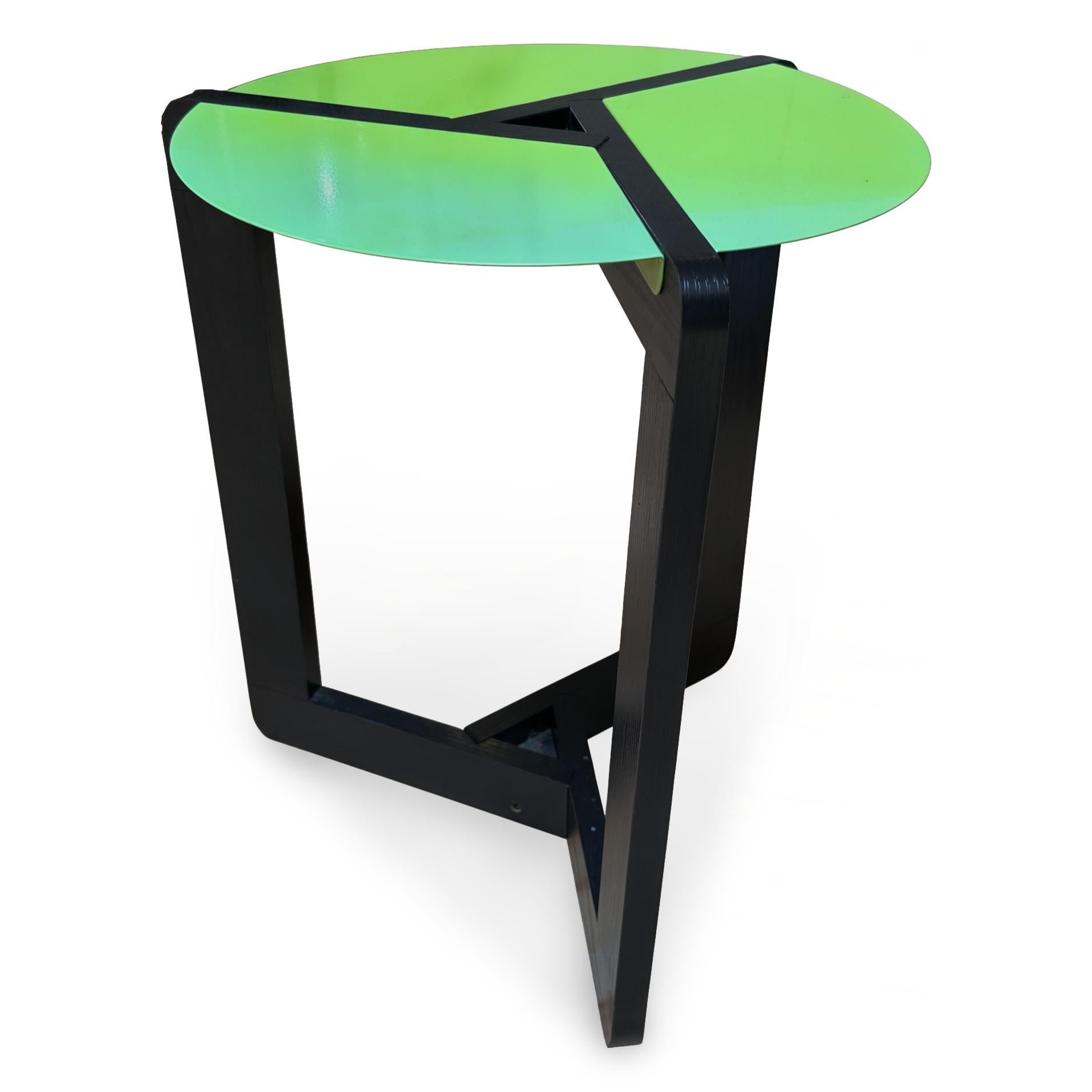 Late 20th century Postmodern enameled metal and wood side table, made in Italy. The table has three enameled red metal panels on a black wood frame. In excellent condition, with some fading to one side of the table top.

Diameter: 15 in / Height: 18