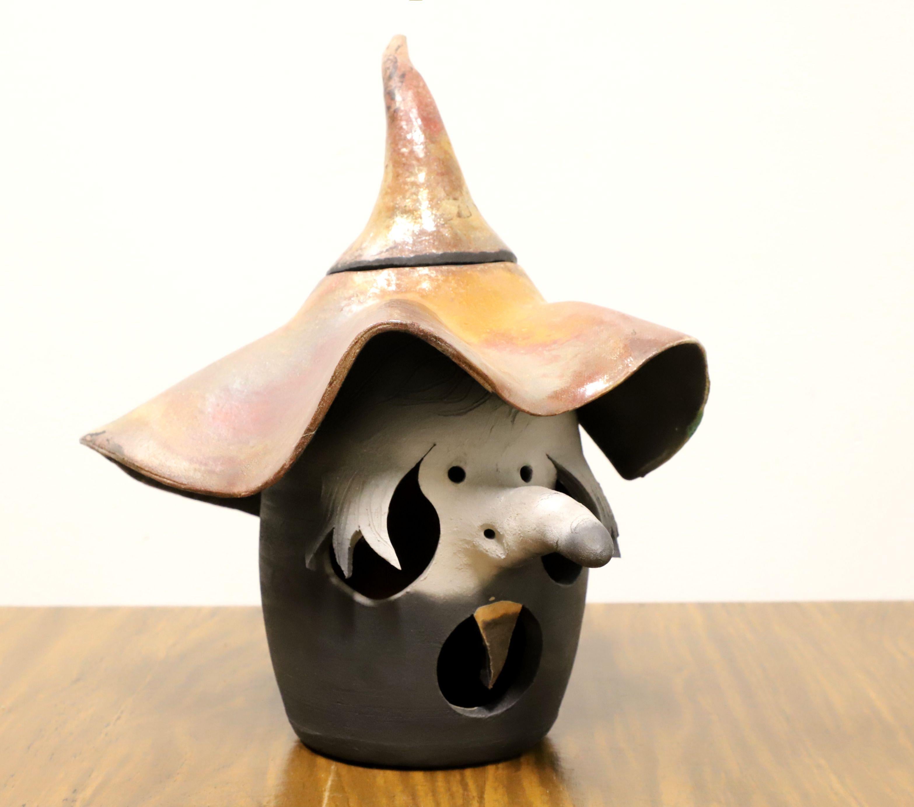 A Late 20th century pottery witches head with hat jack-o-lantern, artist unknown. Ceramic pottery with glaze. Could be used with a candle. Likely crafted in the USA.

Measures: 10.5w 12.25d 13h, Weighs Approximately: 5 lb

Exceptionally good