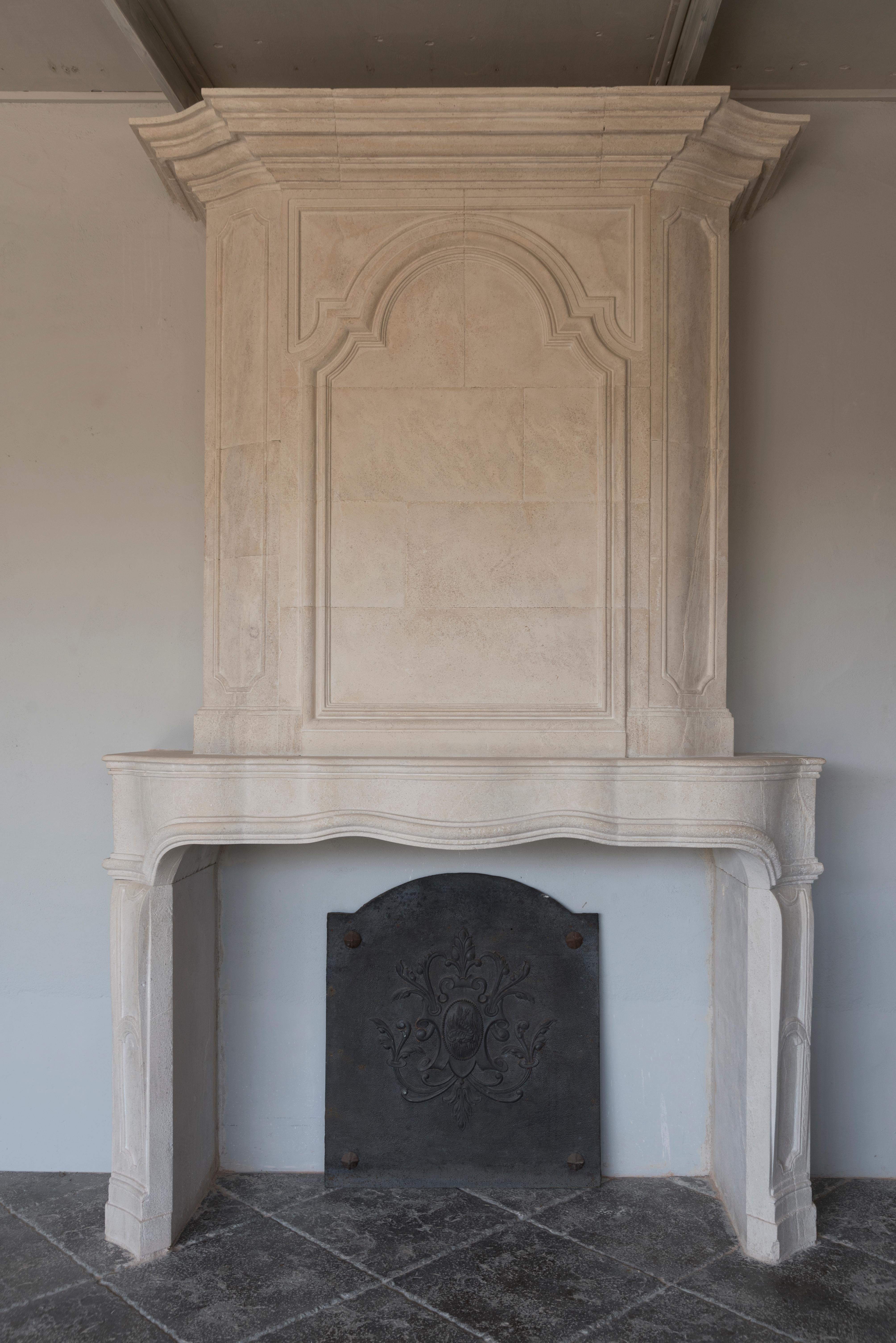 This magnificent reissue of fireplace with his overmantel due to its   manufacturing and moulded work intricately carved by hand, also the surface ageing process of the stone make it a unique piece for prestigious interior decoration project and