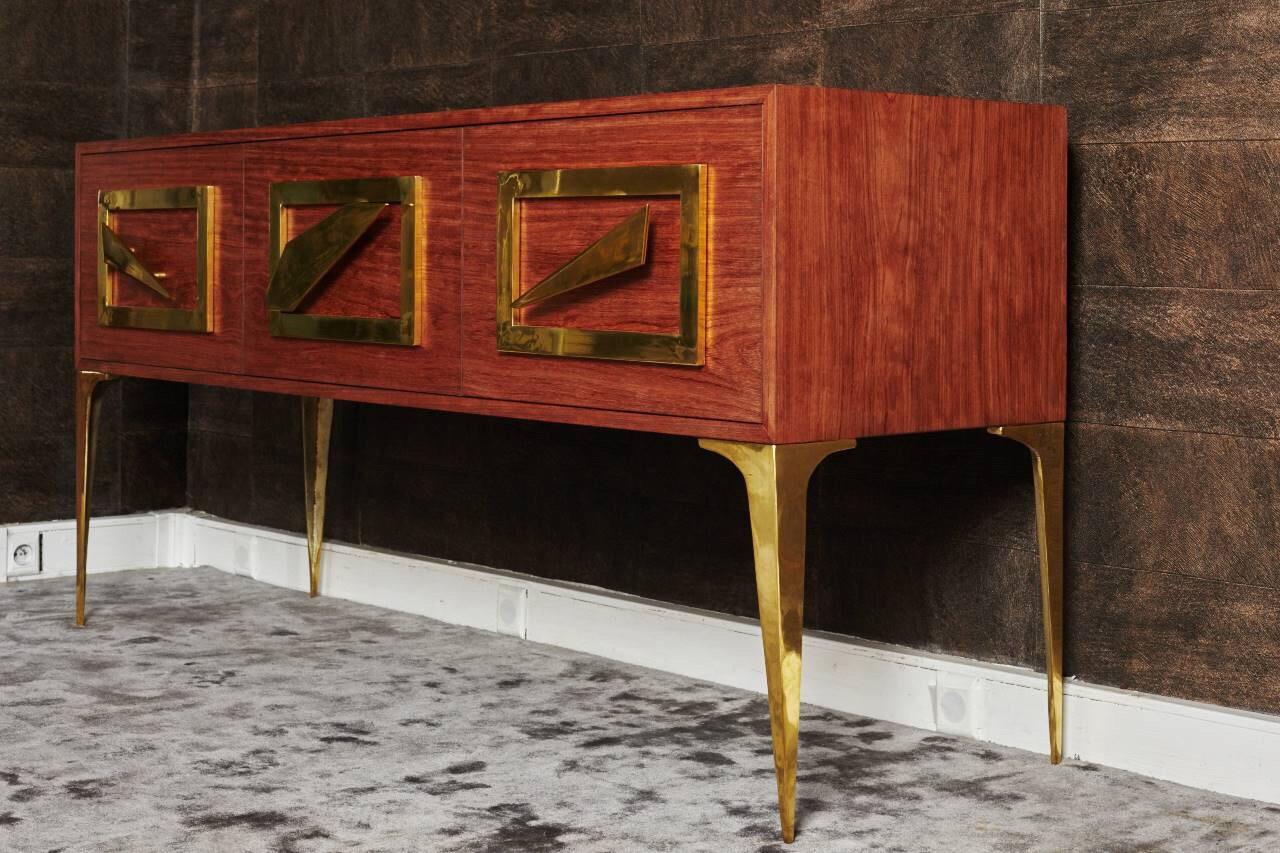 Rectangular rosewood dresser. 
It has three very tall, spacious drawers finished by three wonderful gilded brass design handles. 
It stands on four elegant gilded brass design legs. 
The simple elegance of its lines lets it go perfectly in any