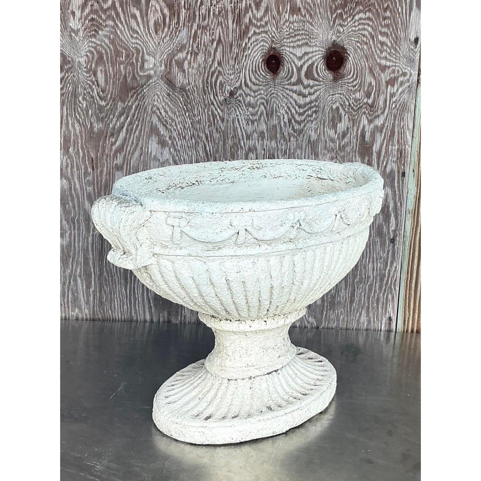 Elevate your home or garden with the timeless grandeur of this vintage Regency-style cast concrete planter. Its elegant oval form is beautifully adorned with classic swag and festoon detailing, complemented by stately handles and a robust pedestal