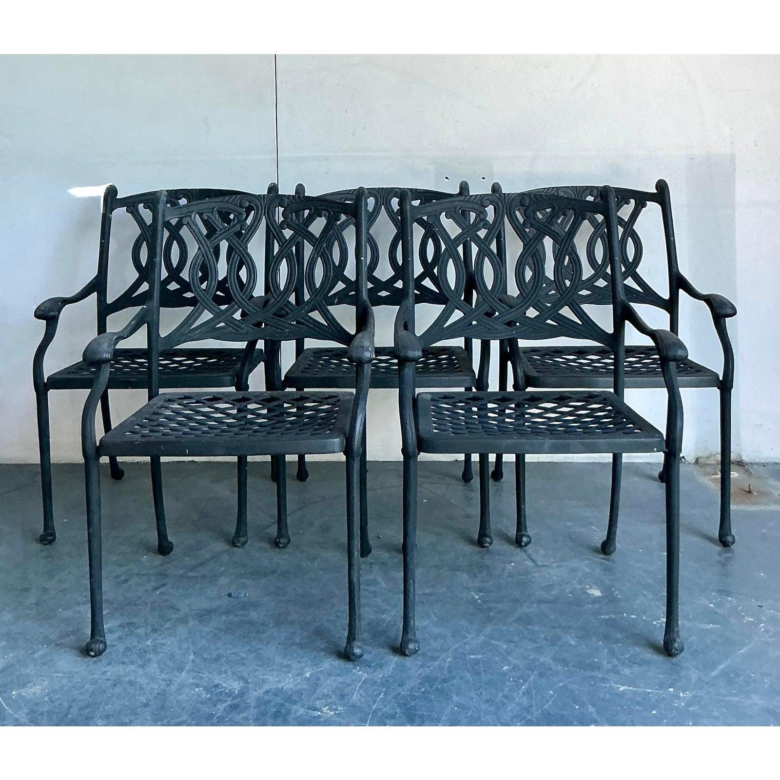 Impresionante juego de cinco sillas de comedor vintage de hierro forjado de la Regencia, que destilan elegancia atemporal y robusta artesanía. Los respaldos con gráciles volutas y los brazos suavemente curvados muestran el intrincado arte de la