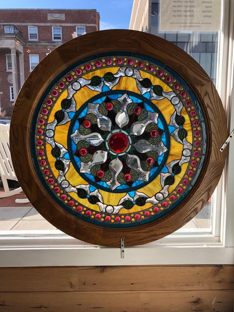 A Spectacular round Jeweled and Beveled stainglass window in a oak frame. This window is loaded with jewels and the combination of stained and beveled glass makes it a very colorful Stainglass window. With a 3