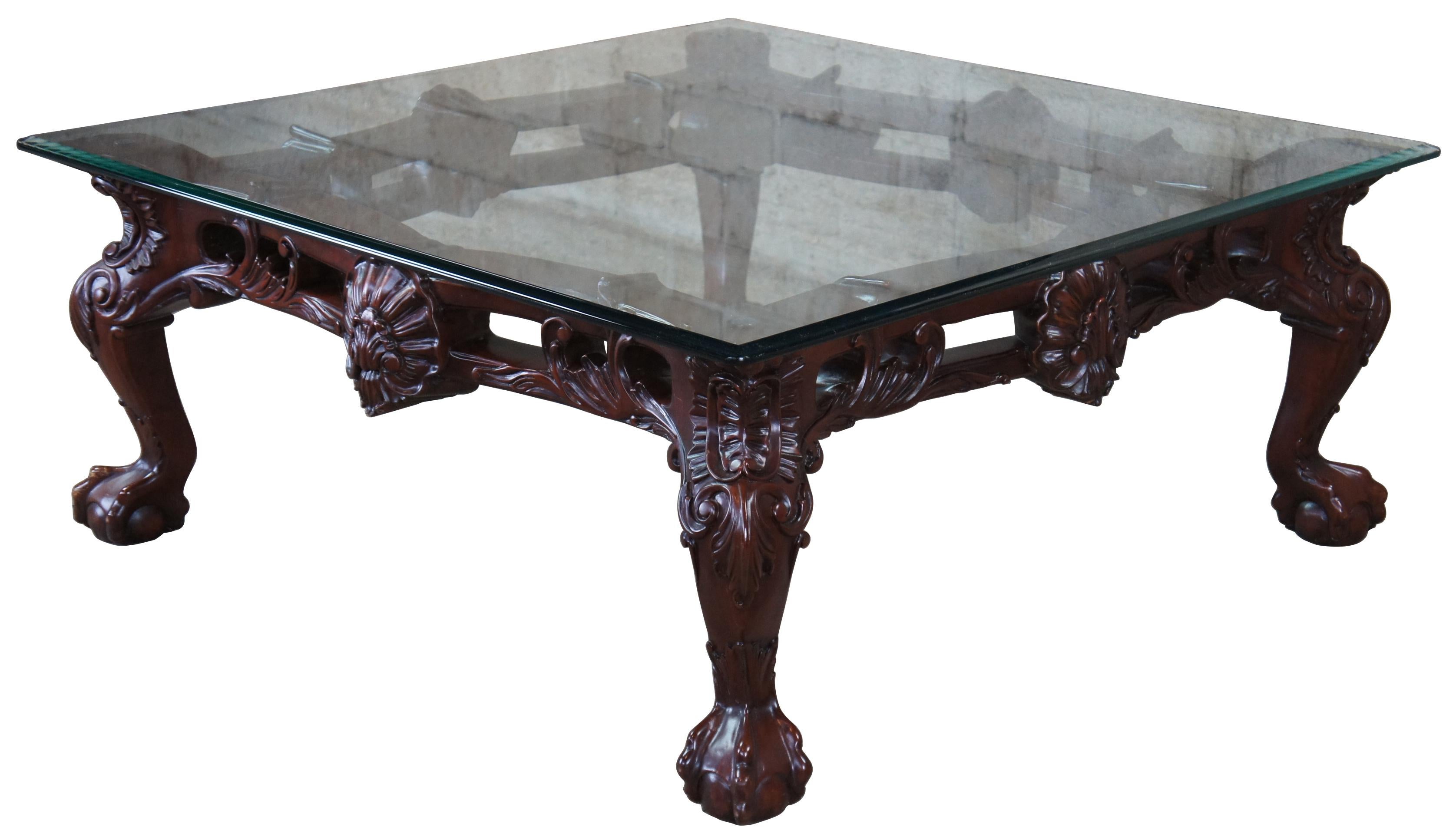 Late 20th century mahogany and glass top coffee table. Features ornate Chippendale styling with scalloped accents, scrolled legs, and ball and claw feet.
  