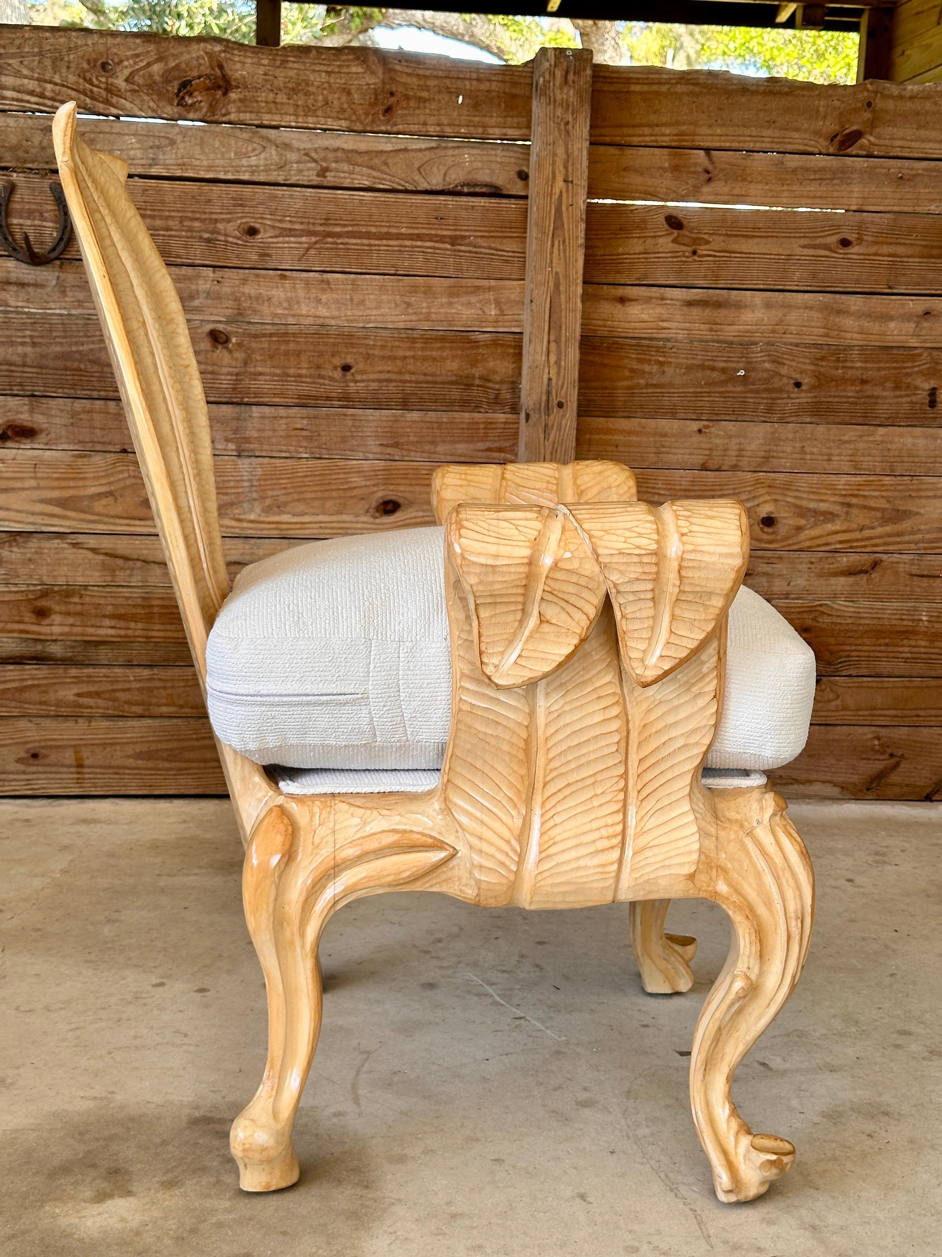 Ce fauteuil en bois sculpté de manière complexe présente un design frappant avec des détails sculpturaux de feuilles et de formes fluides, mettant en valeur un savoir-faire artisanal expert. Récemment remis à neuf, il a été doté d'un nouveau coussin