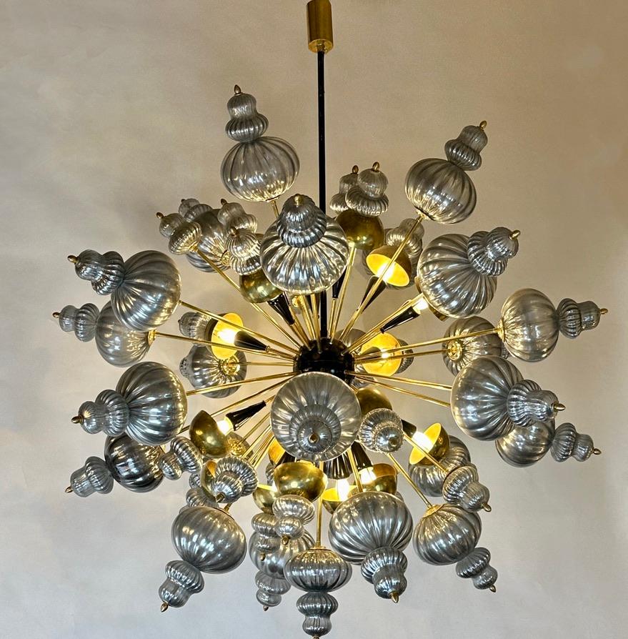 Stunning sputnik chandelier with silver hand blown Murano art glass elements and 16 light bulbs E14 type with brass domes.