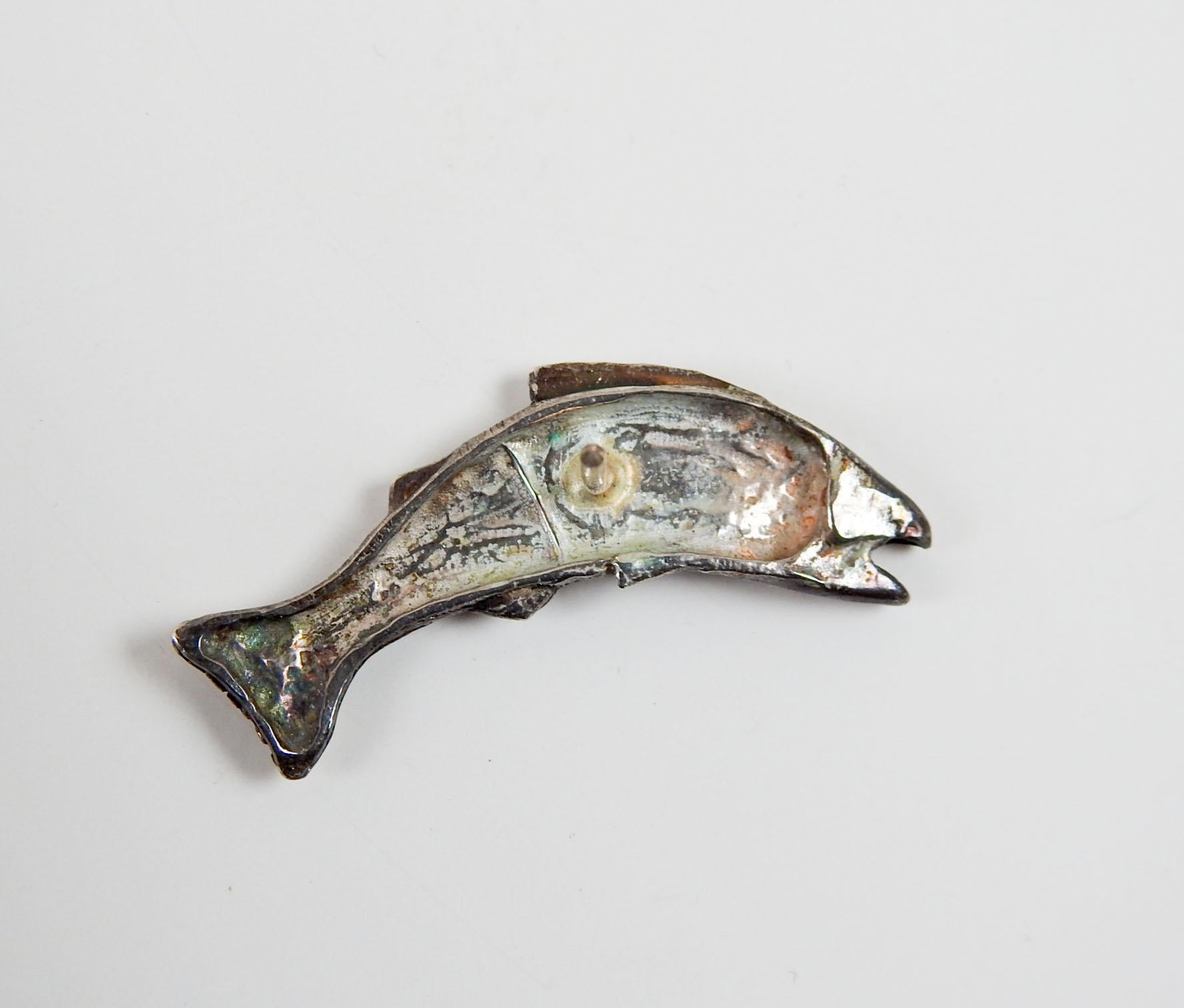 Late 20th century sculptural trout or salmon fish tie tack. No markings, but looks to be artist studio made, cast silver with tiny areas of gold overlay on tail, fins and eye. Great texture and movement, very good condition.