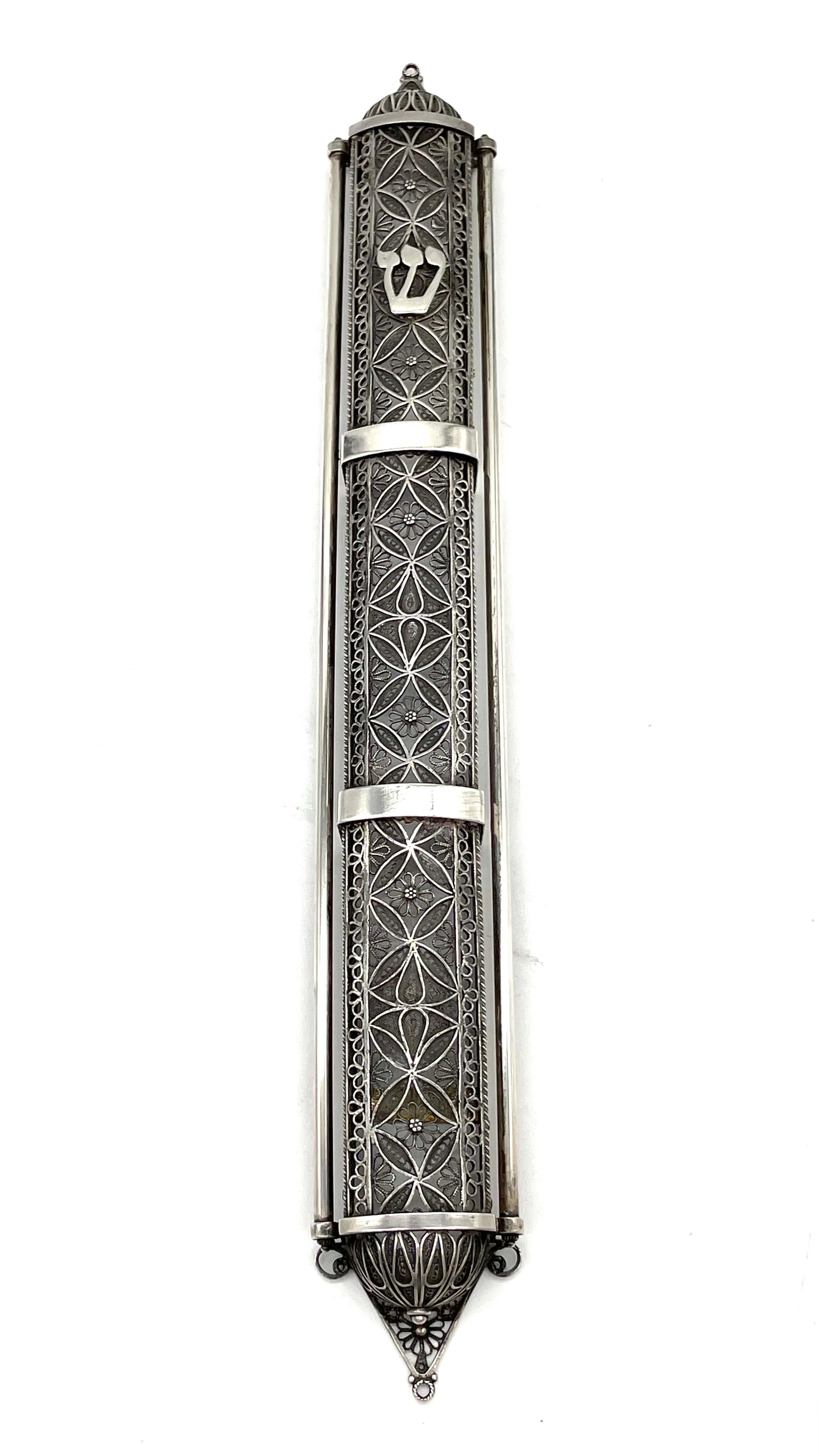 A beautiful, large silver mezuzah case, made in Jerusalem by the artist Chaim Gershi. Signed by the artist and dated, the case is handcrafted in a unique filigree design, showcasing geometrical figures and floral elements throughout, while the