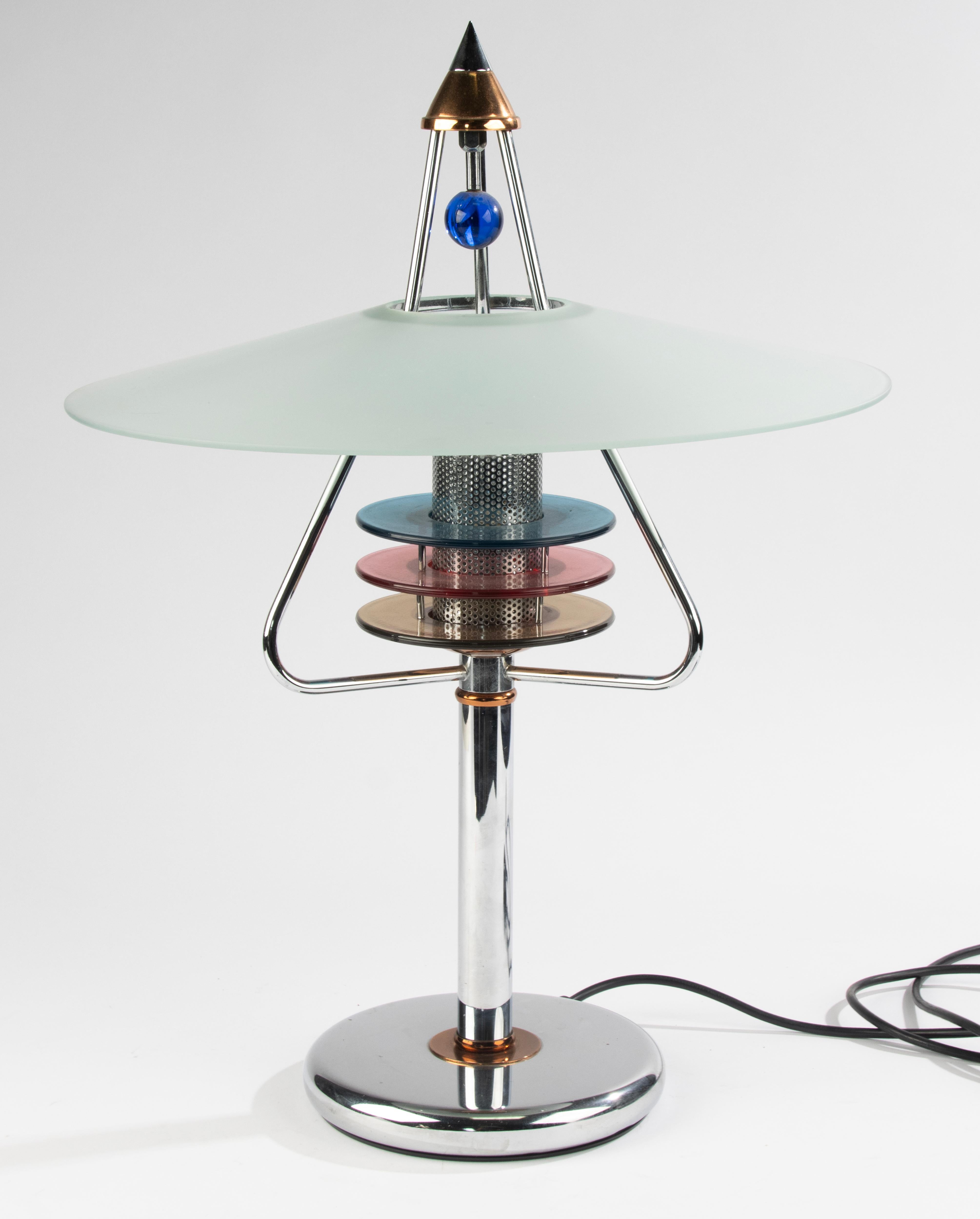 A beautiful post-modern table lamp in Memphis style design.
Made of chrome plated metal and glass.
The lamp is from the German maker Neukro Menden. Little is known about this manufacturer, who probably only existed for a short time. Yet the lamp is