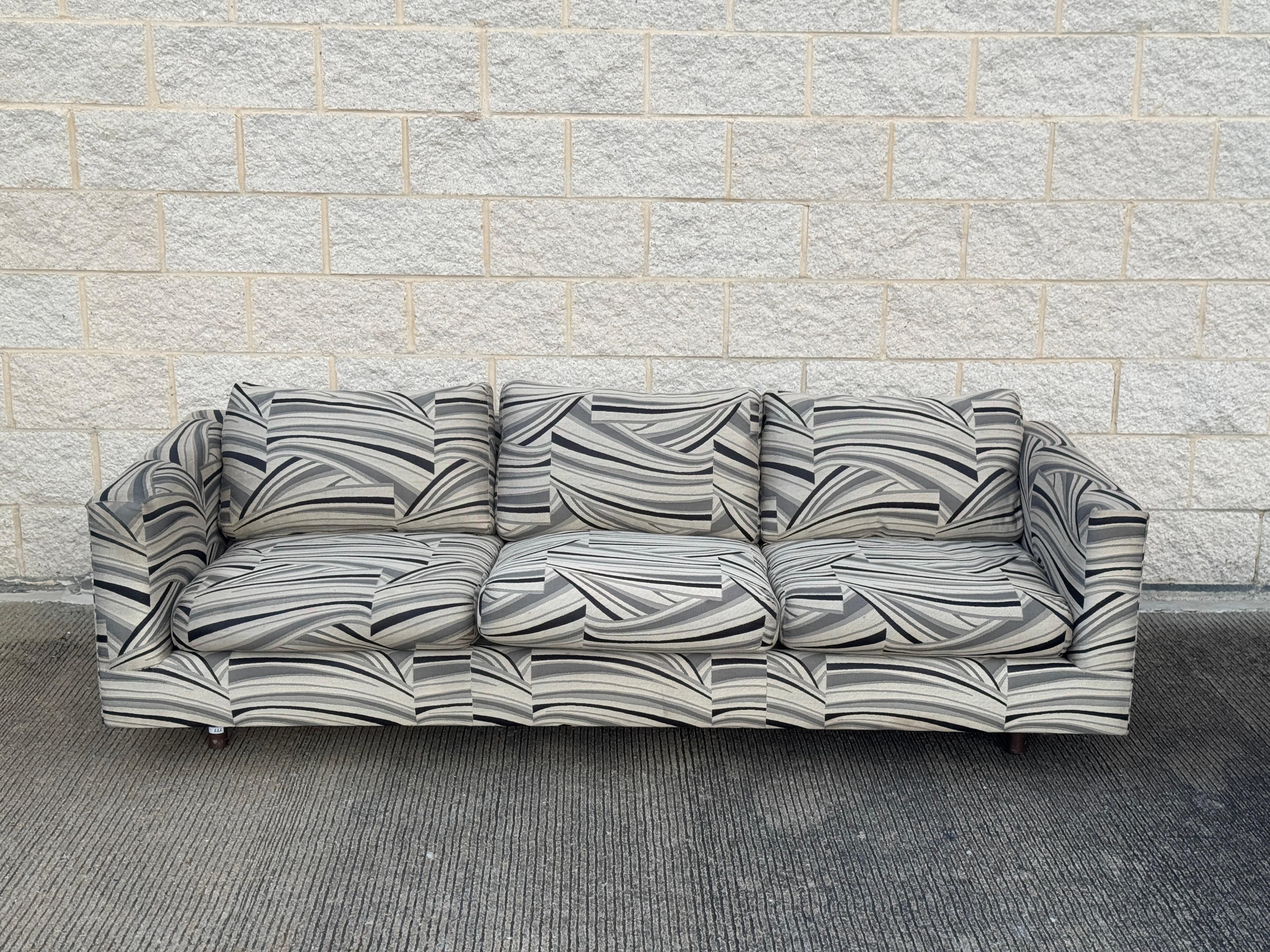 Late 20th-century tuxedo sofa set consisting of two three-seat sofas. Feature a bold black, white, and gray abstract-patterned upholstery. Designed with clean lines, low-profile arms, and deep seat cushions.