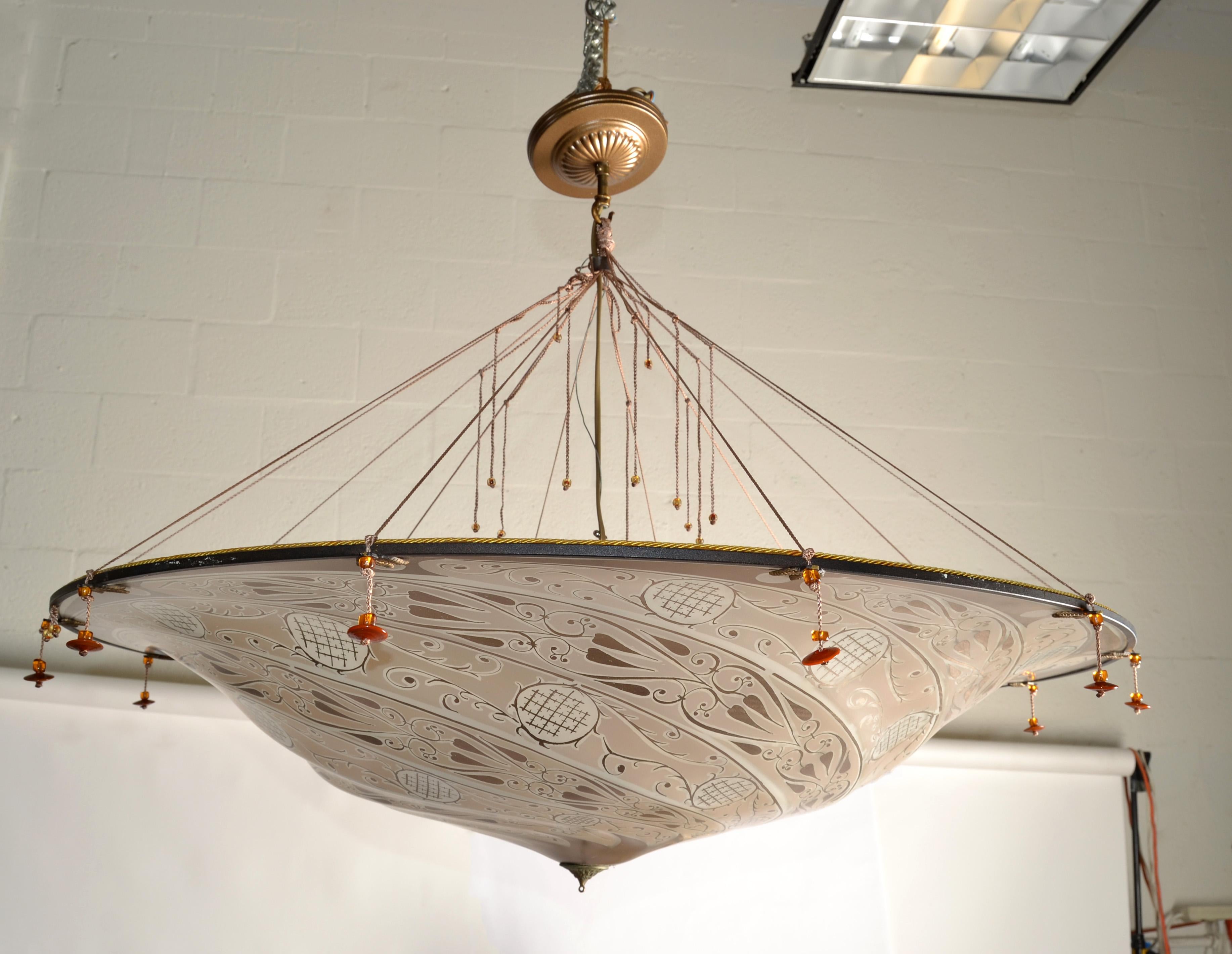 Lustre en verre d'art vénitien Fortuny Scudo Saraceno de la fin du XXe siècle, fabriqué en Italie.
Il combine l'amour de Mariano Fortuny pour les cultures vénitienne et orientale.
Lustre italien en soie à motif Scudo Saraceno (bouclier sarrasin),