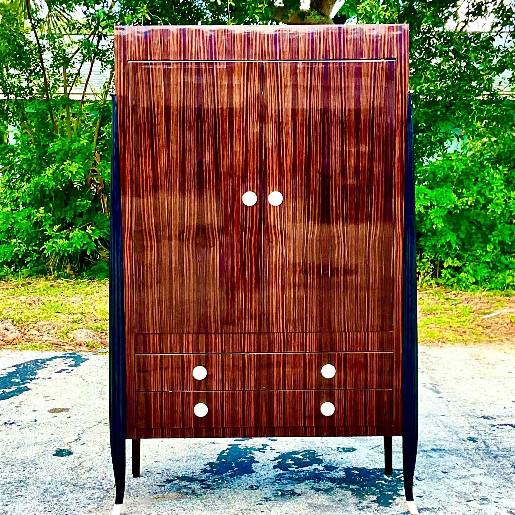 An exceptional vintage Art Deco armoire. Custom built by Victor Rossi. Done in the manner of Emile- Jacques Ruhlmann. A striking ebony and rosewood cabinet in a high gloss finish. Acquired from a Palm Beach estate.