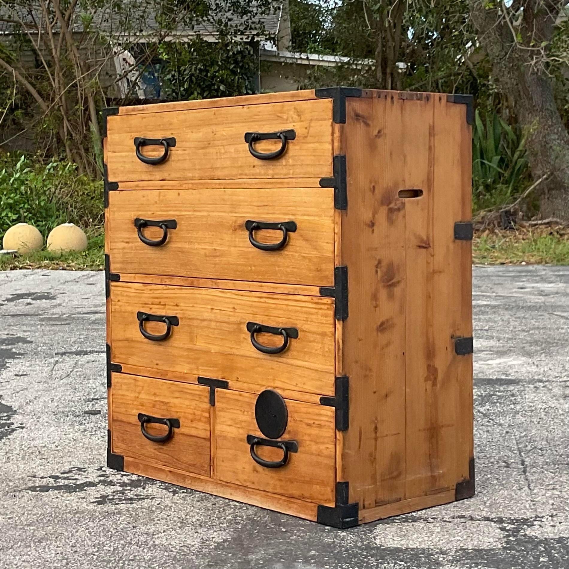 A fantastic vintage Asian chest of drawers. A chic natural wood cabinet with hammered metal hardware. Two open handles on each side. Acquired from a Palm Beach estate.