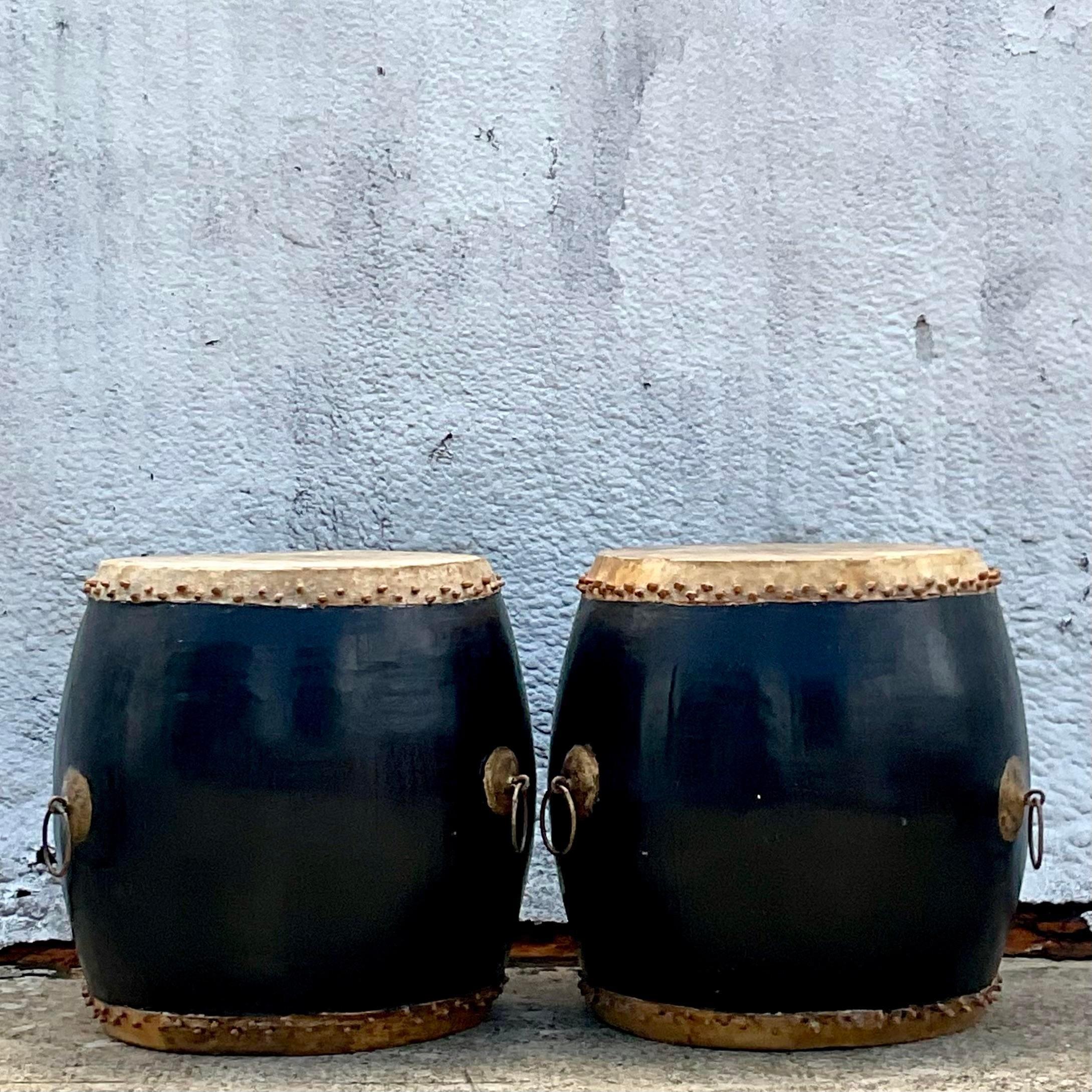 A fabulous pair vintage Asian Side tables. A chic pair of black lacquered barrel bases with a deer skin hide top. Large patinated rings for extra drama. Just add glass to extend the surface area if needed. Acquired from a Palm Beach estate.