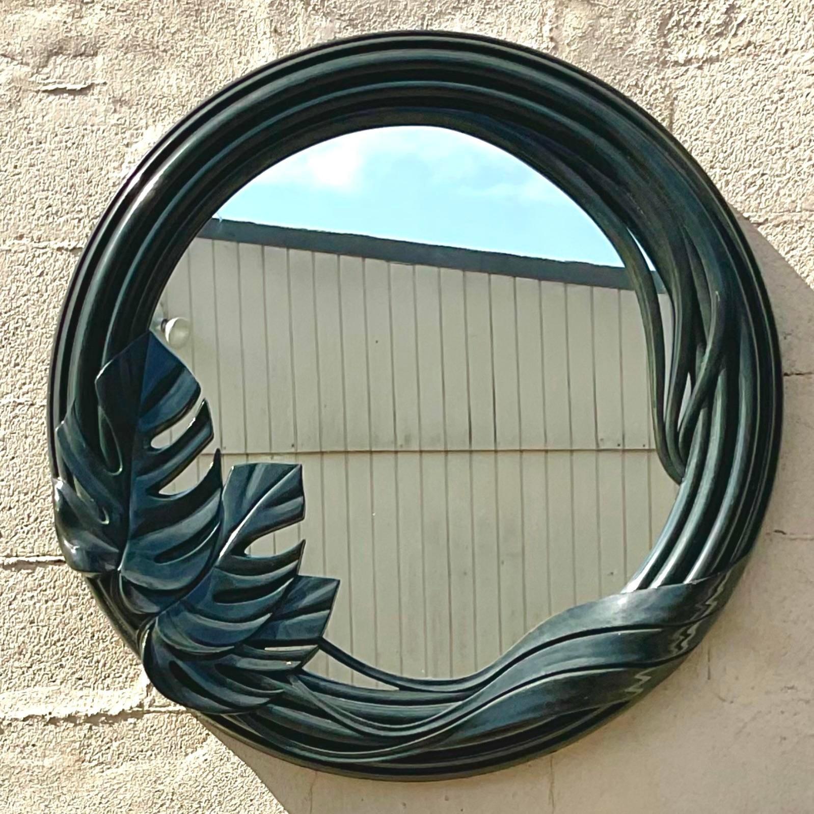 A fabulous vintage Boho wall mirror. A chic round frame with a Monstera motif. Lacquered a deep forest green. Acquired from a Palm Beach estate.