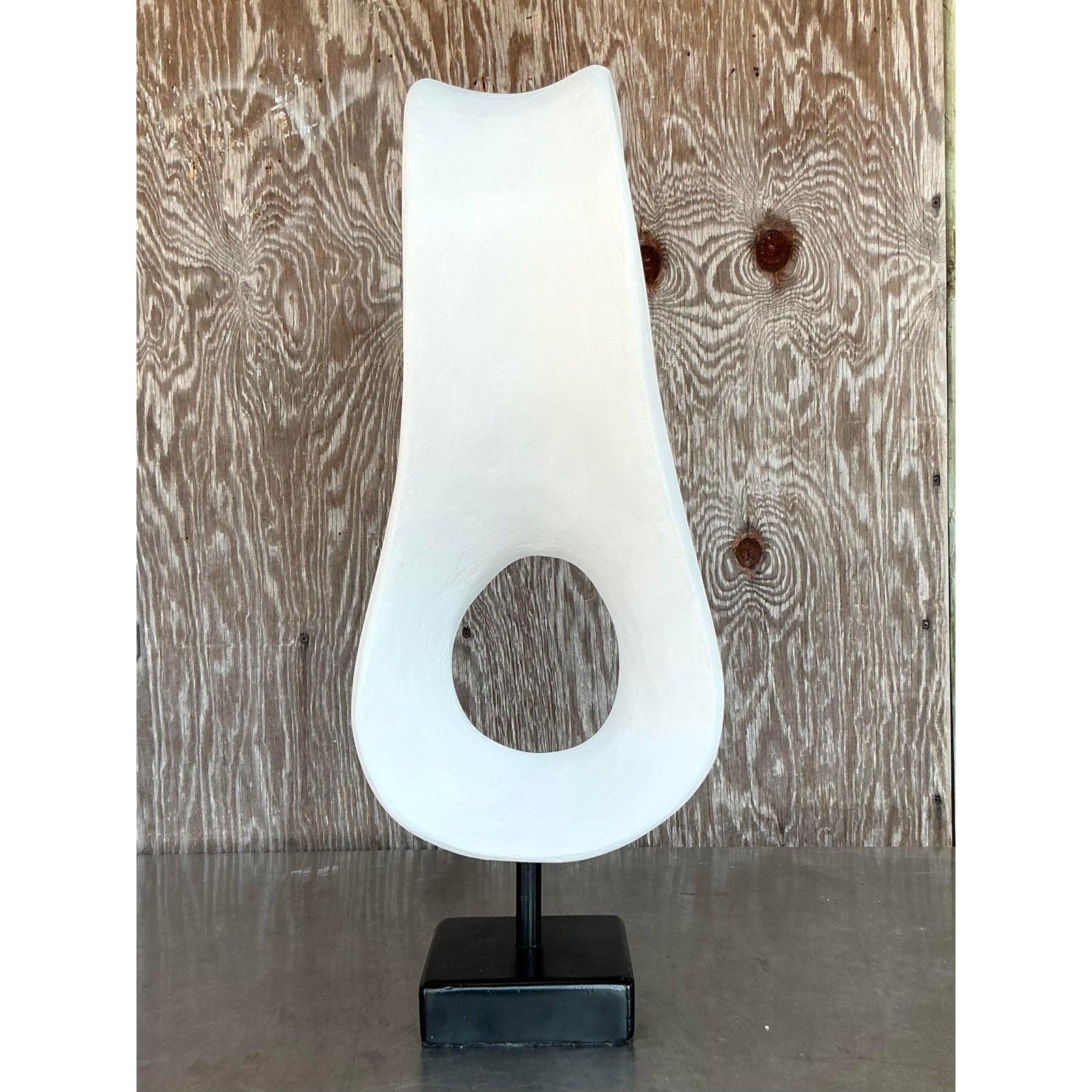 Questa scultura boho vintage in gesso biomorfo, che colpisce da ogni angolazione, è una dichiarazione scultorea in forma organica. Caratterizzato da una silhouette fluida e astratta con un vuoto centrale, questo pezzo evoca la sensibilità dell'arte