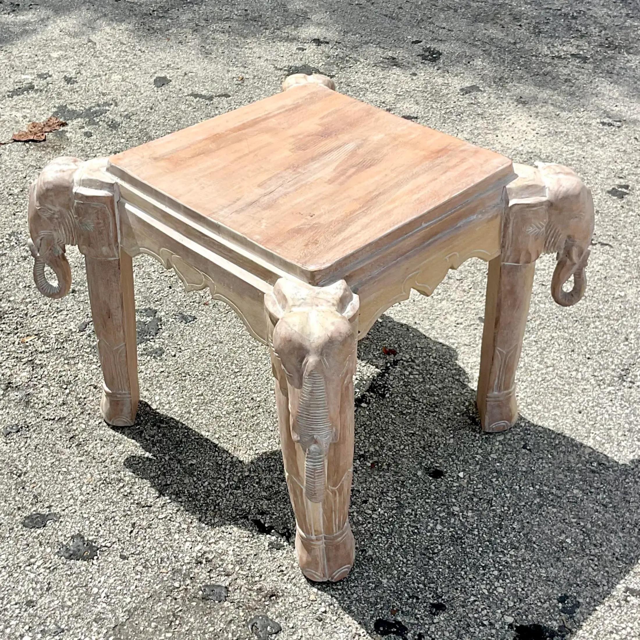 A fabulous vintage Coastal table. Perfect as a side table or even a smaller coffee table. You decide! Beautiful hand carved detail elephant heads on each corner. A chic cerused finish. Acquired from a Palm Beach estate.