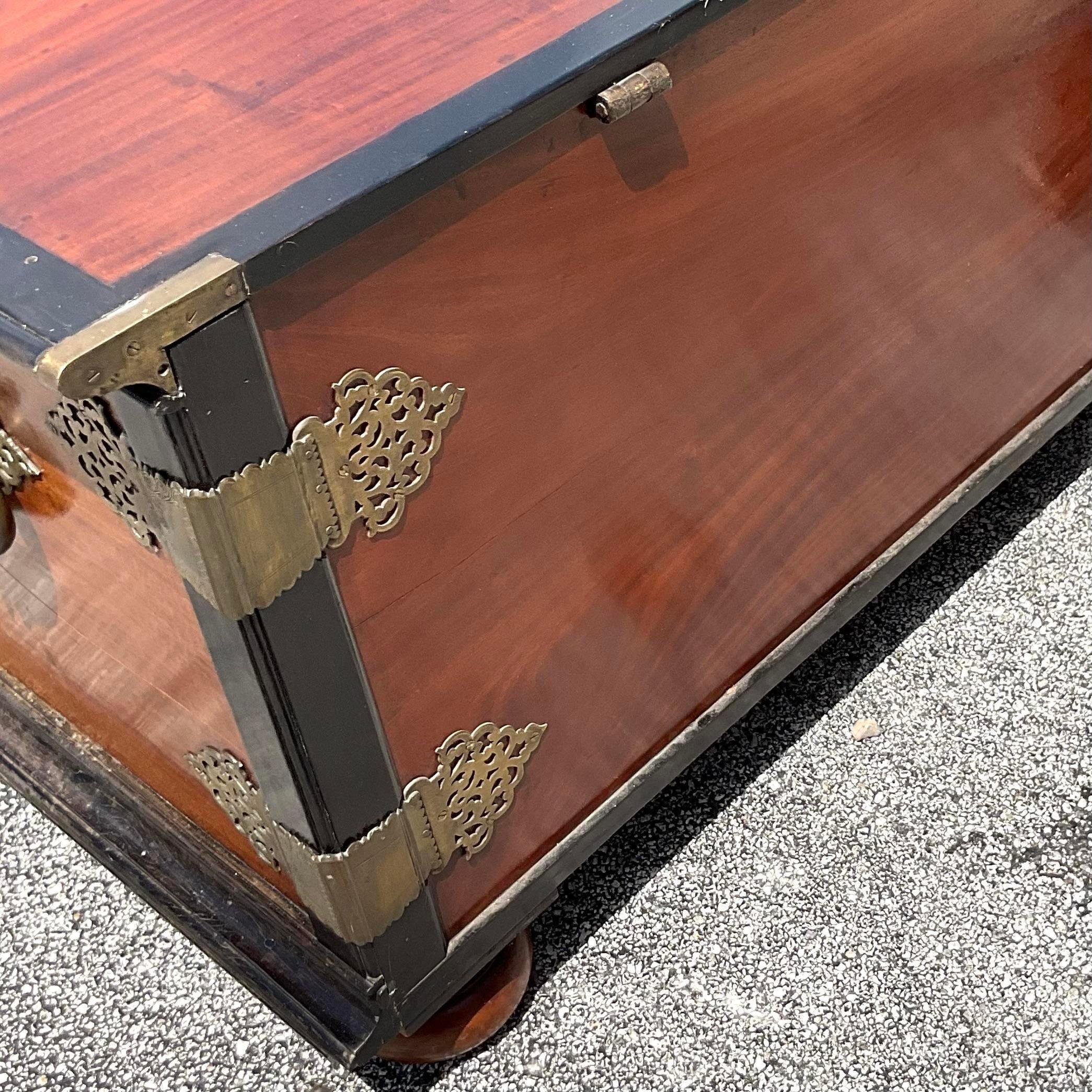 A spectacular vintage Boho blanket chest. Monumental in size and drama. A beautiful ebony and mahogany cabinet with amazing brass hardware. A real showstopper. Acquired from a Palm Beach estate.