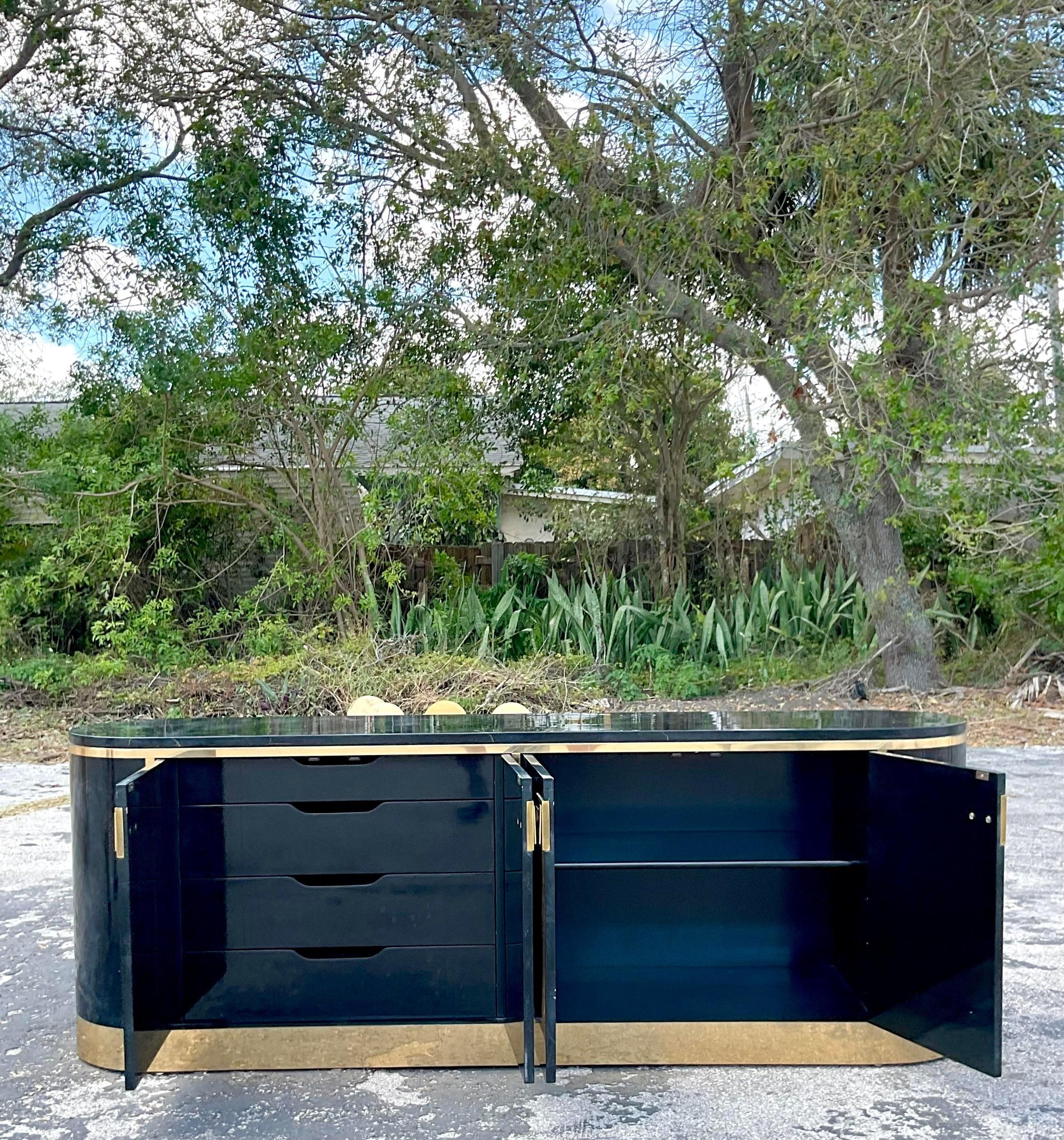 A spectacular vintage Boho credenza. The coveted Racetrack credenza from the Mastercraft group. Tagged on the back. A black and grey piano finish with hand painted gold veining. Heavy brass hardware. Acquired from a Palm Beach estate.
