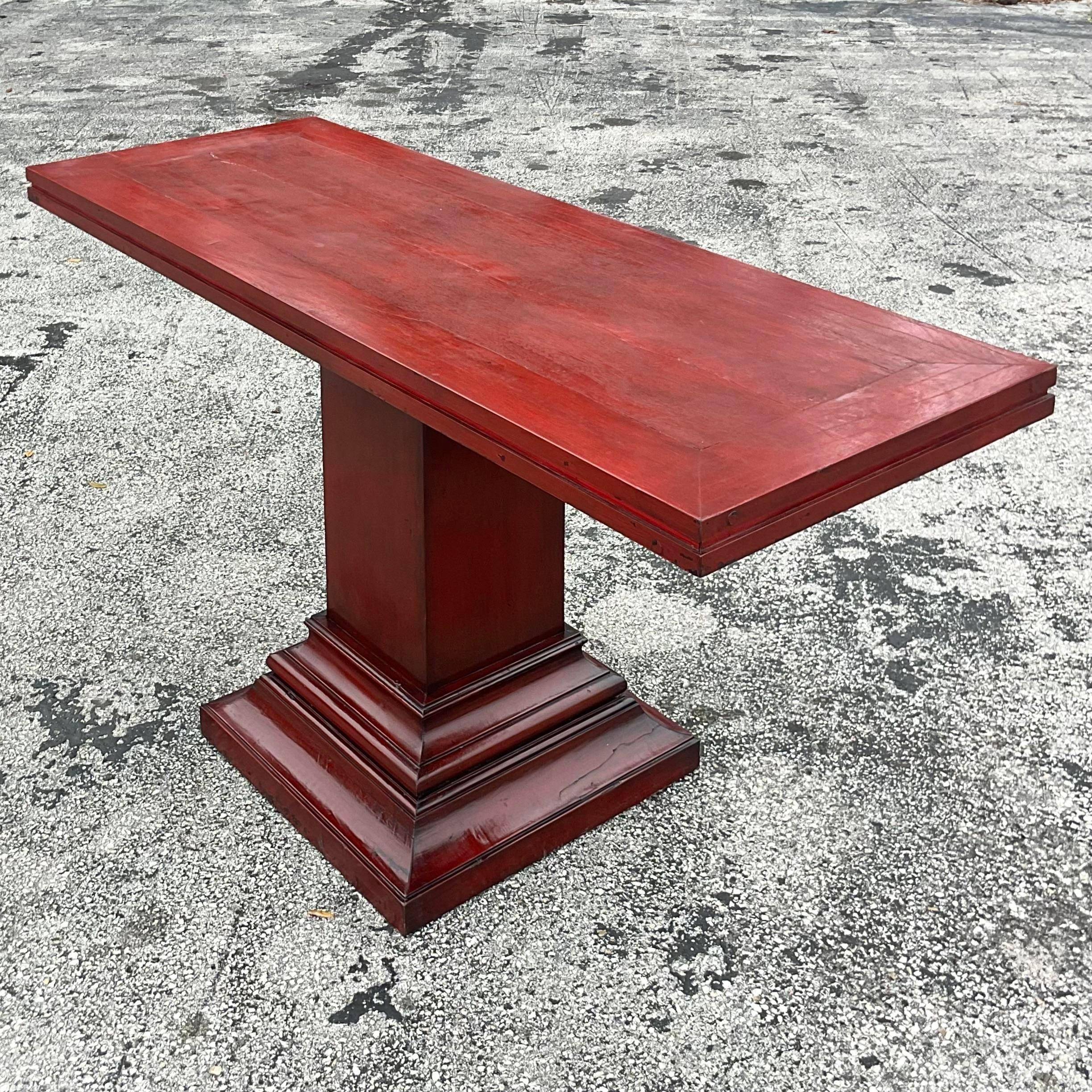 A fantastic vintage Boho console table. A deep red lacquered finish with beautiful stacked Millwork design. Acquired from a Palm Beach estate.