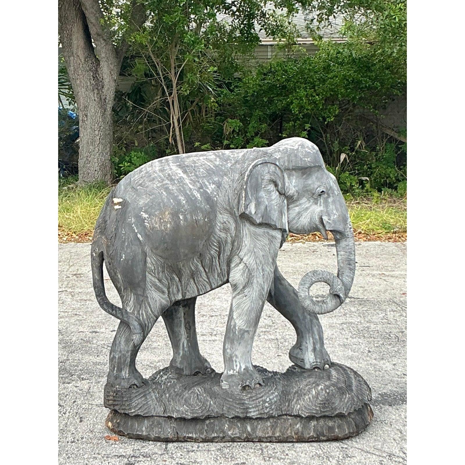 Fai una dichiarazione audace nel tuo spazio con questa scultura mozzafiato di elefante in legno intagliato a mano. Monumentale nelle dimensioni e ricco di carattere, questo pezzo intricato cattura la maestosa essenza dell'elefante con notevoli