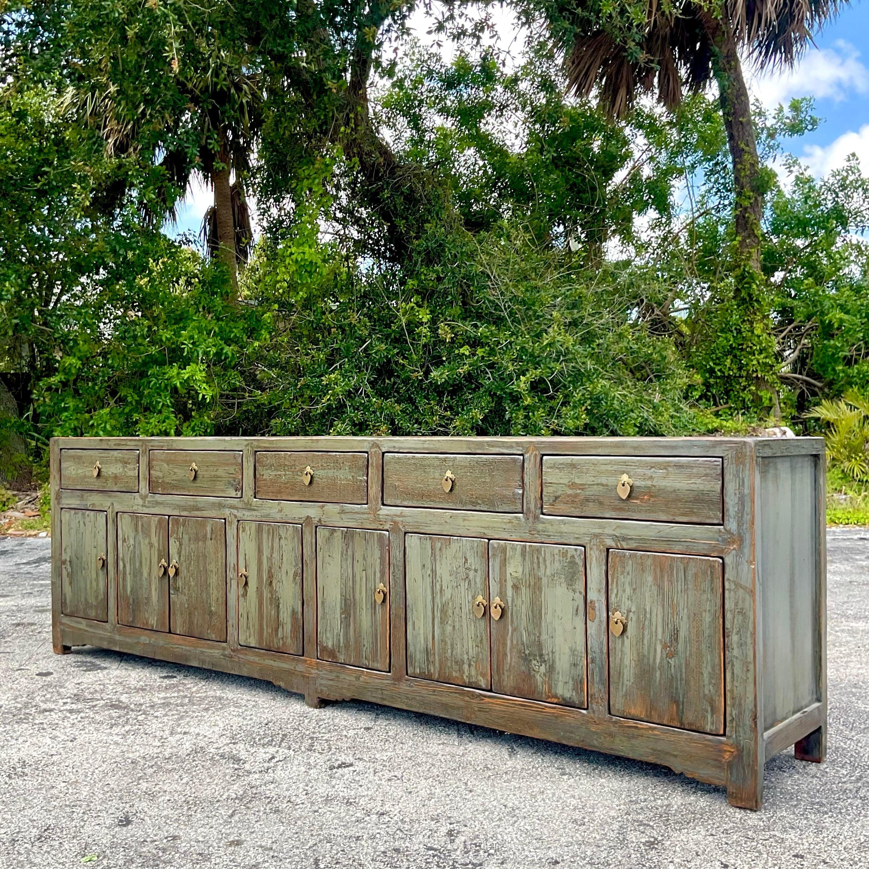 Make a bold statement in your home with our Vintage Boho Monumental Reclaimed Wood Credenza. Crafted with the soul of American craftsmanship and the free spirit of Bohemian design, this piece combines the grandeur of reclaimed wood with intricate