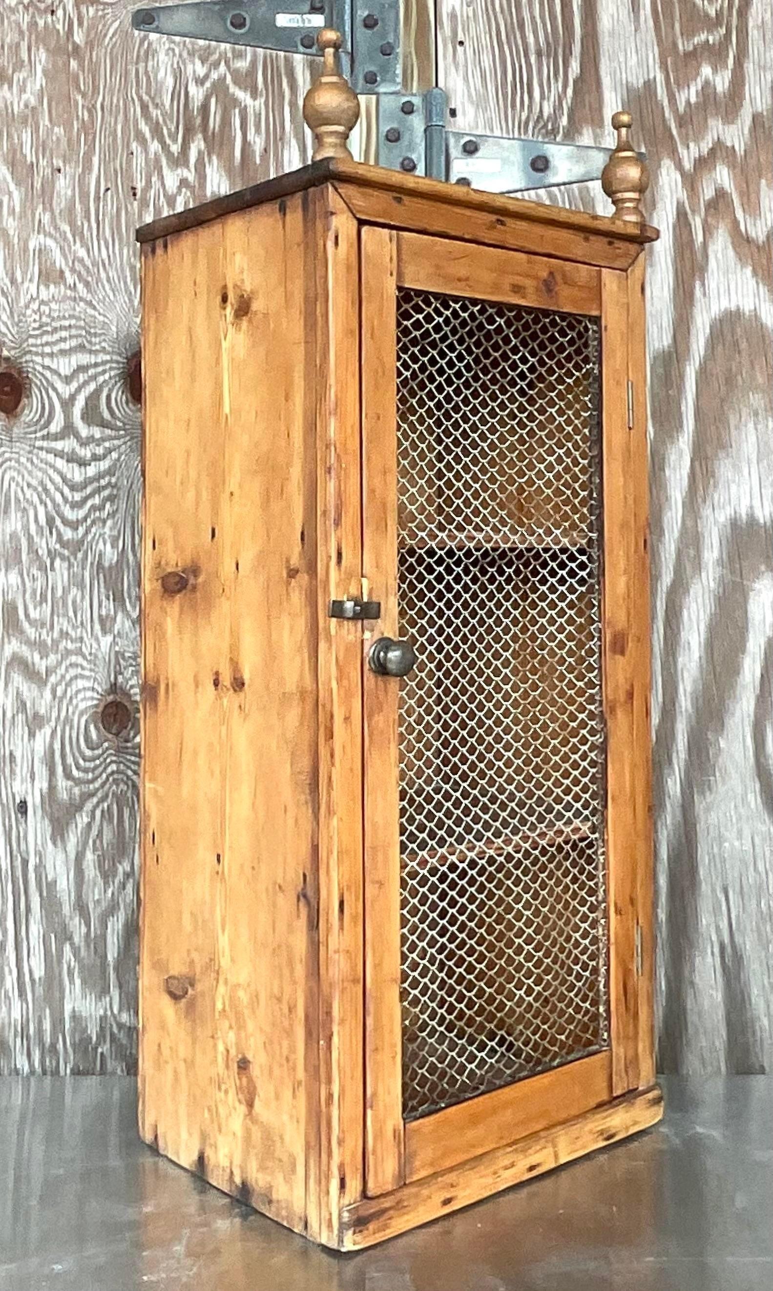 A fabulous vintage Boho wall cabinet. A chic little primitive cupboard for your small treasures. Hand carved finials on top. Perfect on your wall or on your table top. You decide! Open wire door. Acquired from a Palm Beach estate