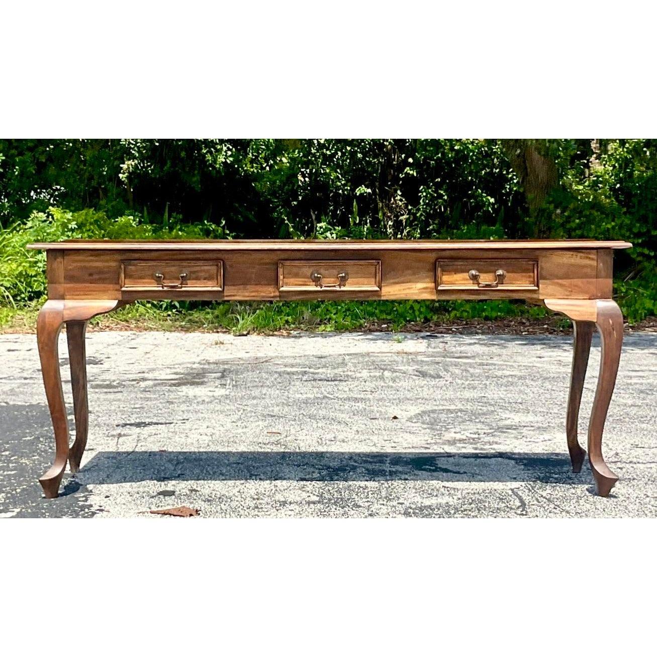A fabulous vintage Boho console table. A chic teak frame with beautiful wood grain detail. Cabriolet legs and heavy brass hardware. Acquired from a Palm Beach estate