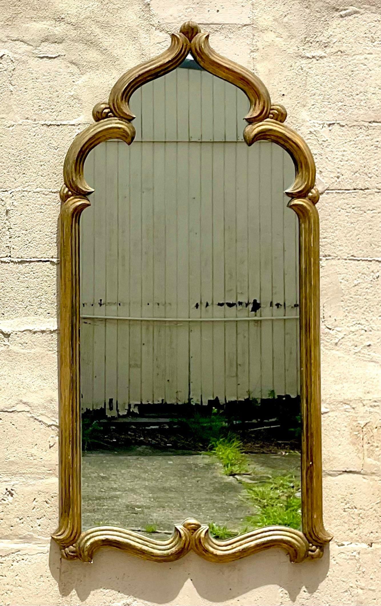 A fabulous vintage Boho wall mirror. A chic Moroccan style frame with a gilt finish. Monumental in size and drama. Acquired from a Palm Beach estate.