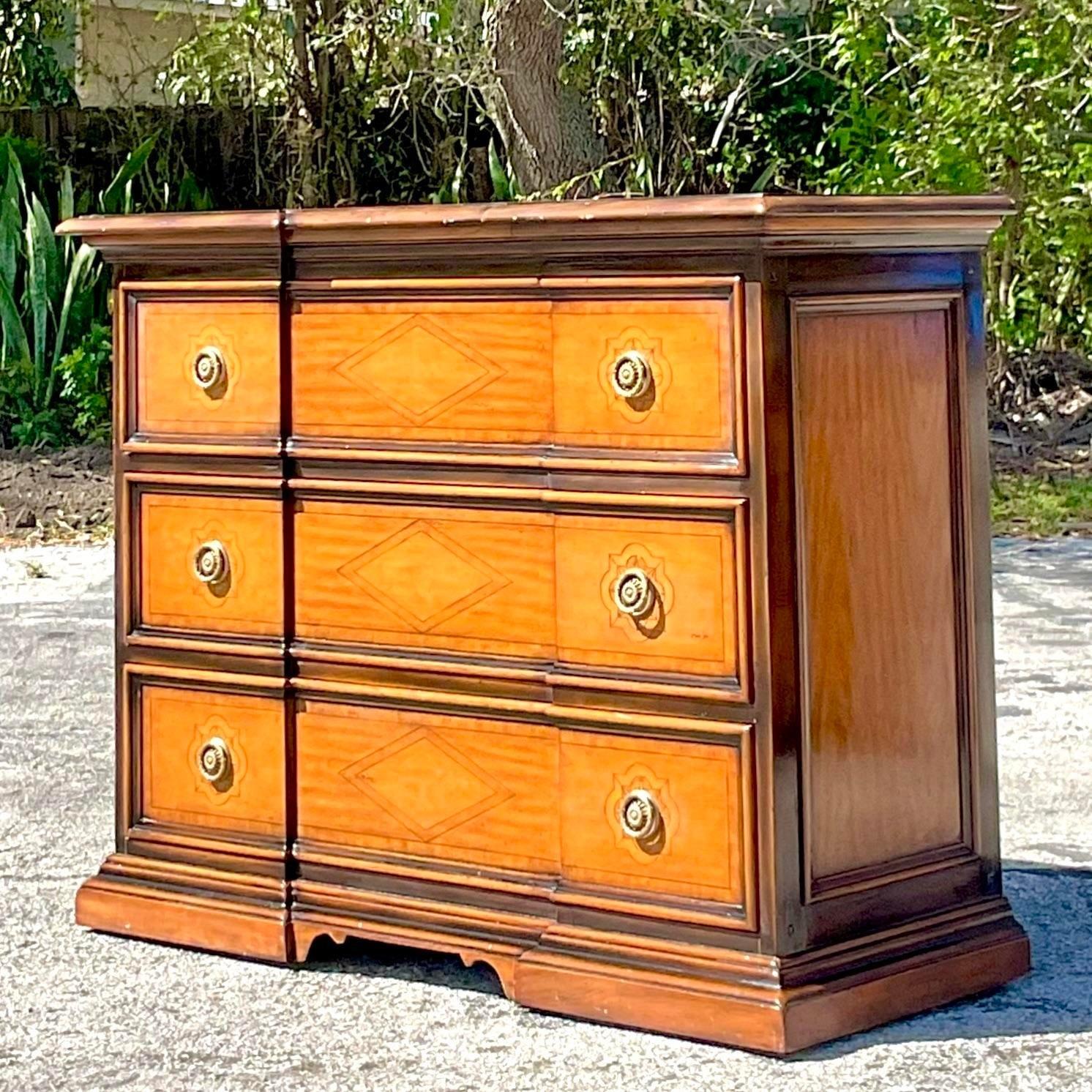 A fabulous vintage Boho chest of drawers. Made by the iconic Theodore Alexander group and tagged inside the drawer. A gorgeous marquetry top and roll front design. Acquired from a Palm Beach estate.
