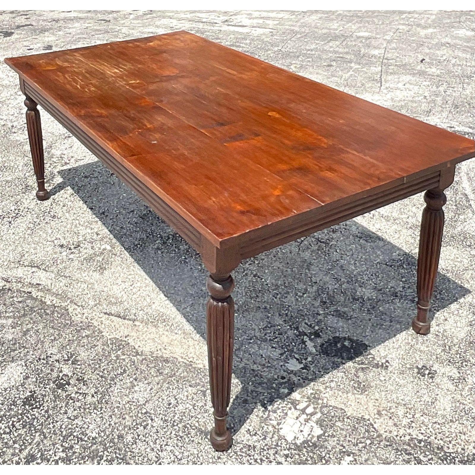 A fabulous vintage Boho dining table. A chic farm table with a beautiful patinated finish. Made of a solid walnut with carved details in the apron and legs. Acquired from a Palm Beach estate.