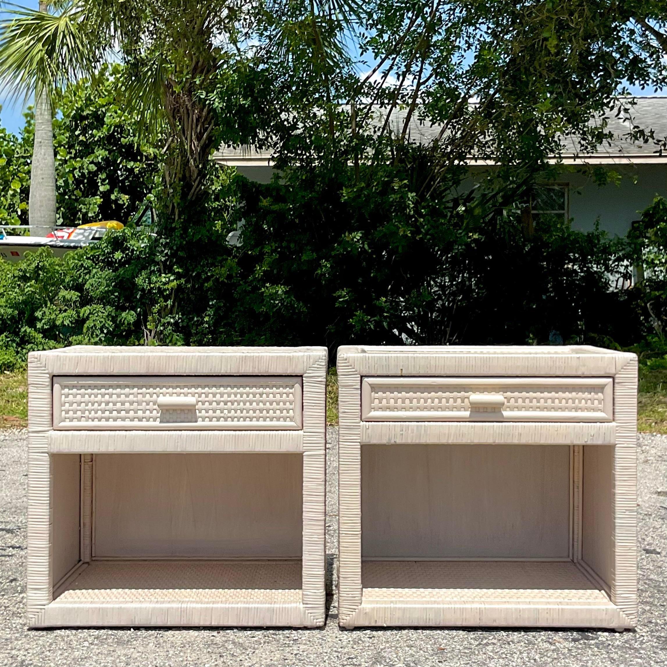A fabulous pair of vintage Coastal nightstands. Chic cerused rattan in a wrapped and woven design. Lots of great storage below and one drawer each. Acquired from a Palm Beach estate.