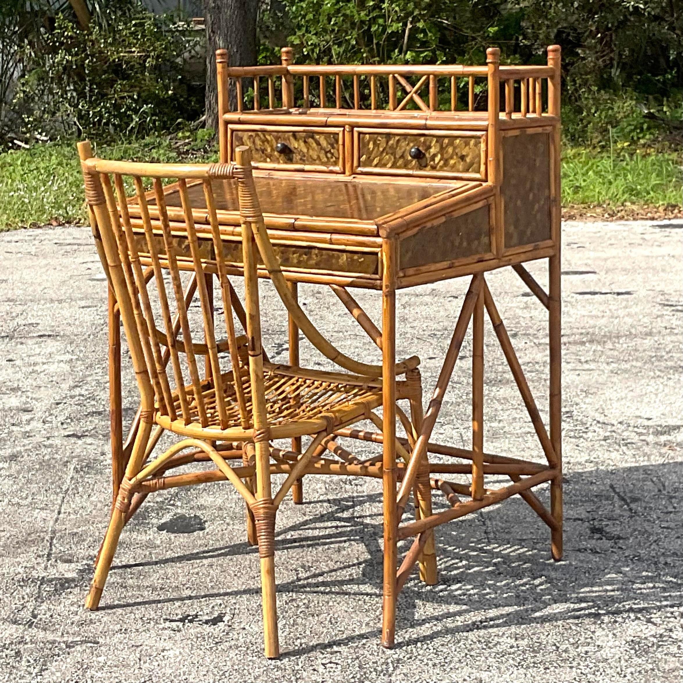 A fantastic vintage Boho writing desk. A chic burnt bamboo beams with gorgeous gold detailing along the panels. The desk is a sloped writing surface with storage below for your supplies and paper. Coordinating bent rattan chair included. Acquired