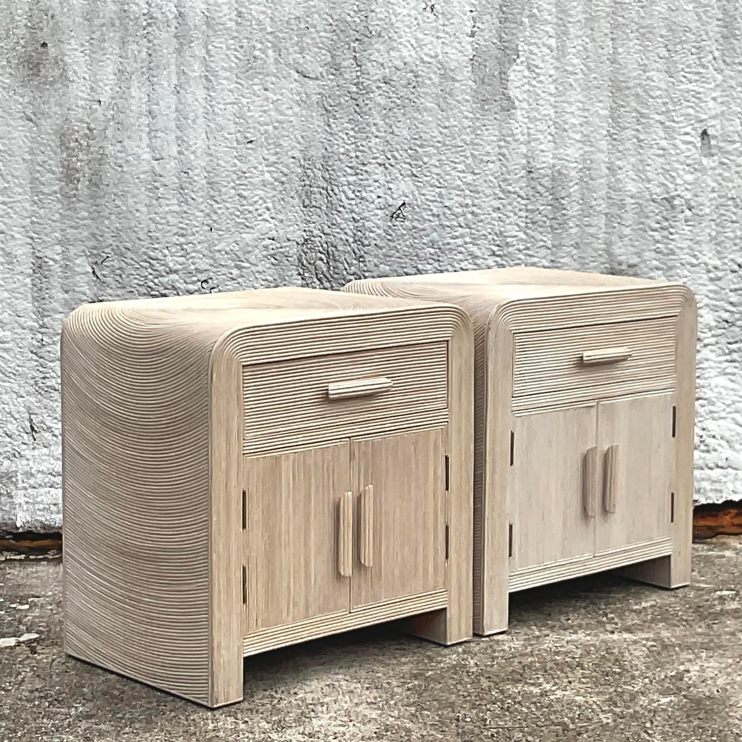 A fabulous pair of vintage Coastal nightstand. A chic pencil reed cabinet with a modern cerused finish. A waterfall edge with the coveted starburst design on top. Acquired from a Palm Beach estate.