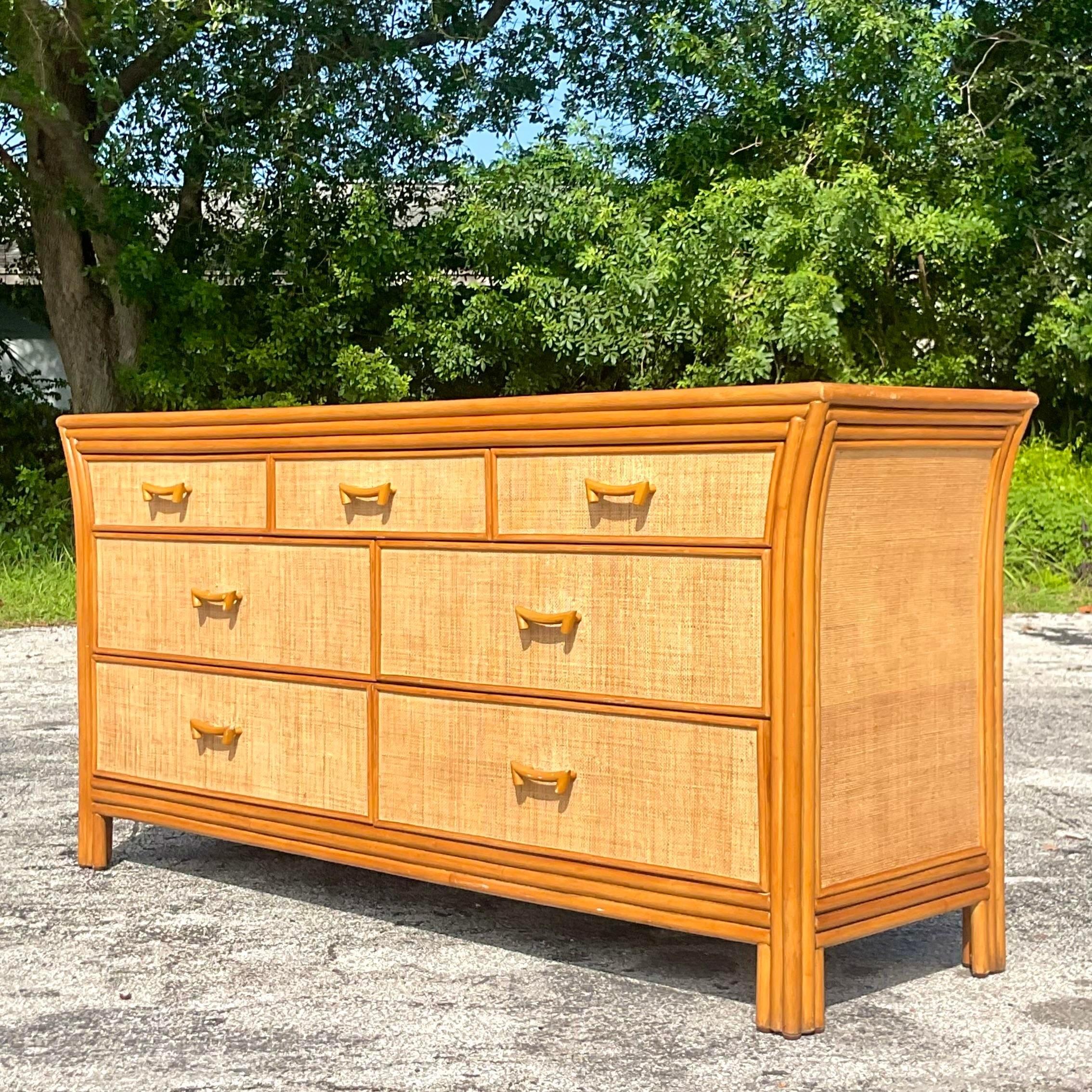 A fantastic vintage Coastal dresser. A chic combo of rattan frame and inset Grasscloth panels. Fabulous swag rattan drawer pulls. Acquired from a Palm Beach estate. 