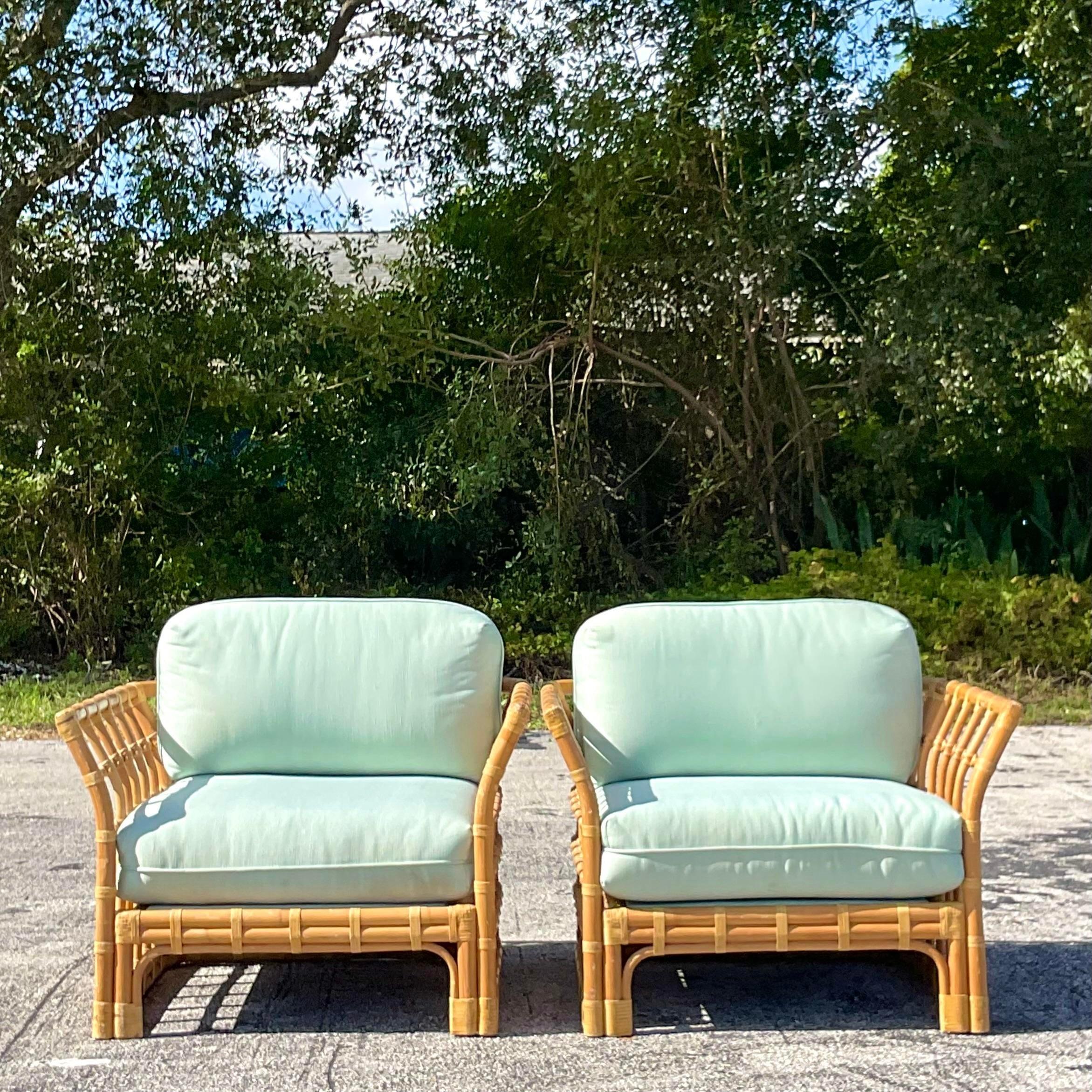 A stunning pair of vintage Coastal lounge chairs. A chic grid design with a winged shape. Deep seats with a pale green cushion. Acquired from a Palm Beach estate.