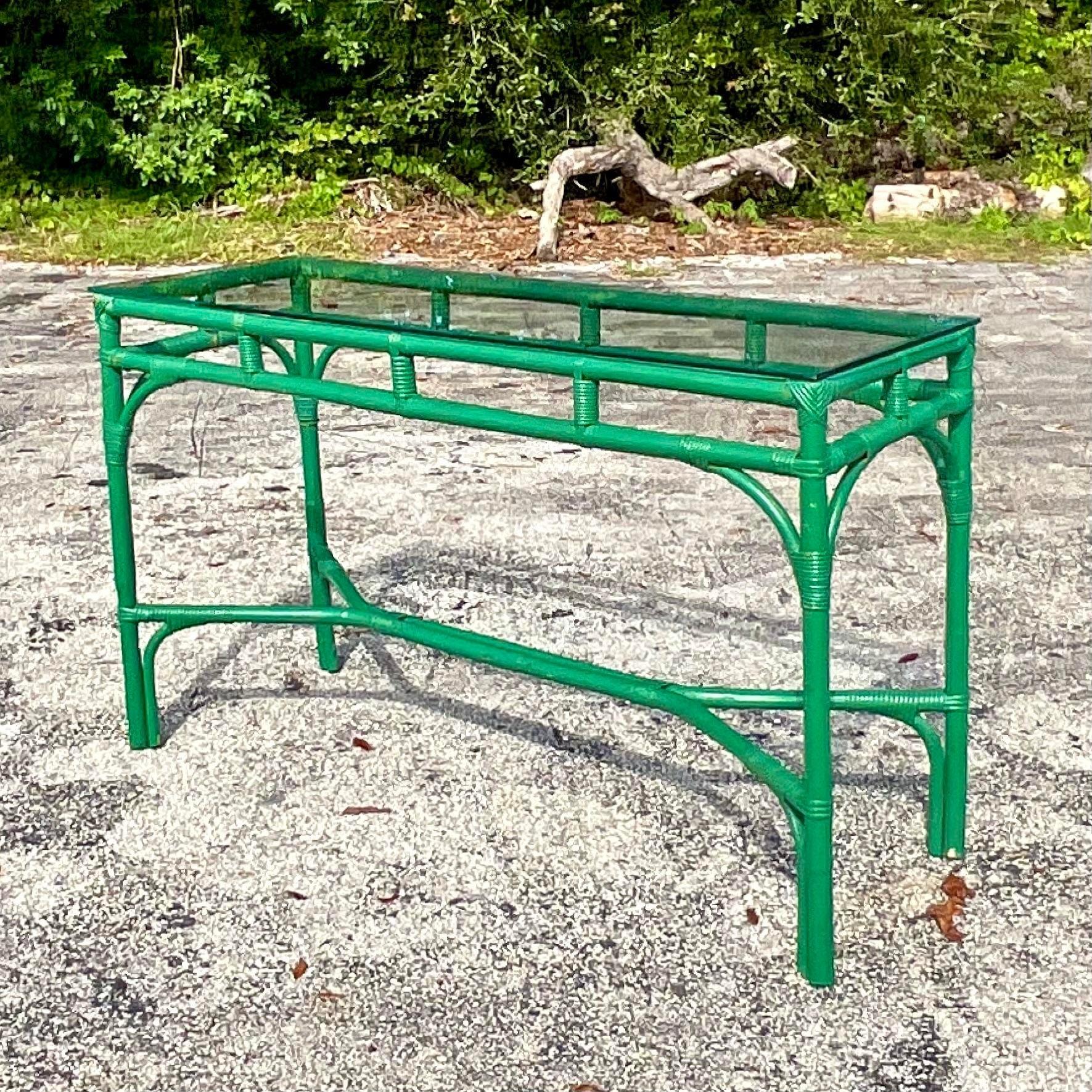 A fabulous vintage Coastal console table. Painted a bright Kelly green with a glass top. A charming addition to any space. Acquired from a Palm Beach estate. 