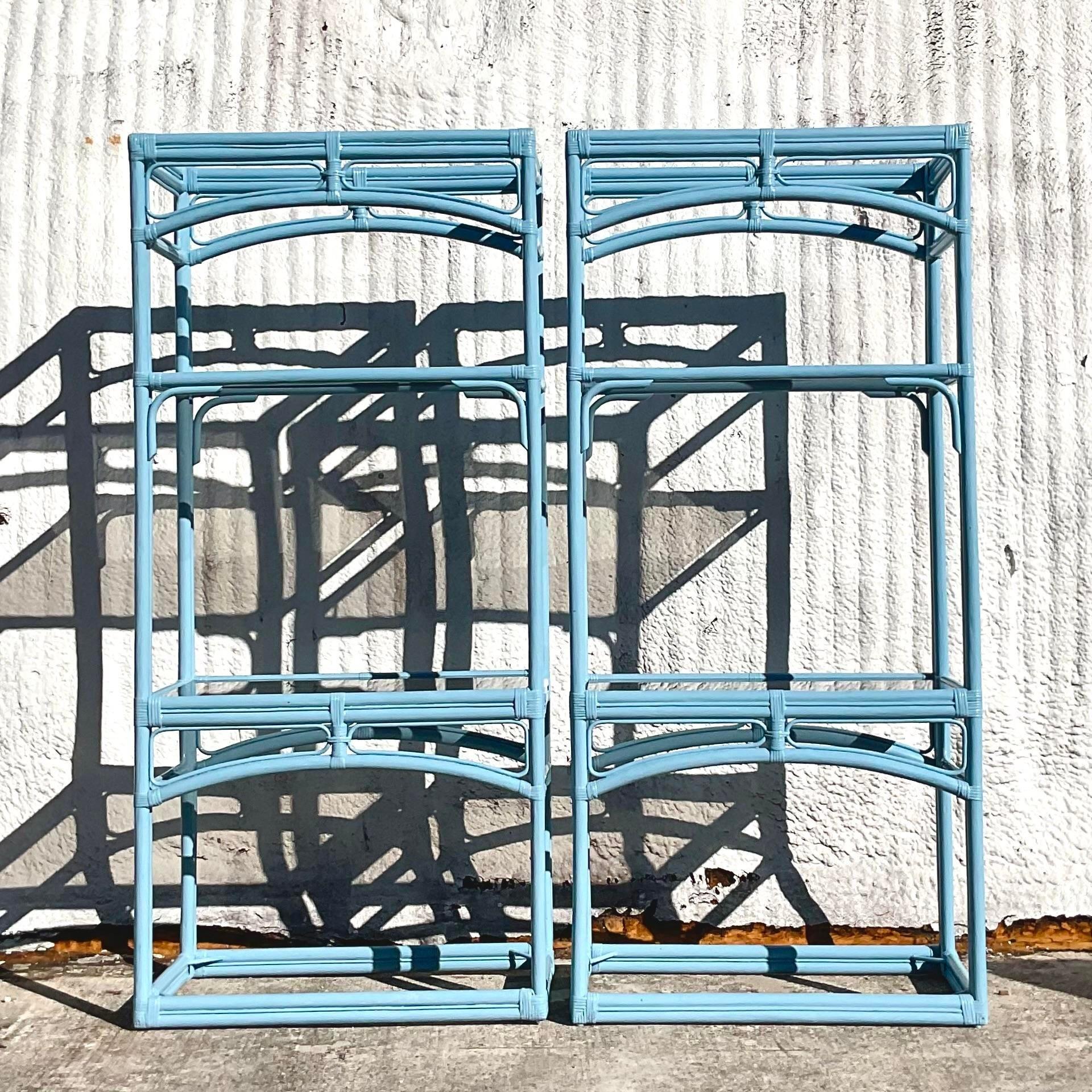 A fabulous pair of vintage Coastal etagere. A rattan frame that has been painted a beautiful pale blue. Inset tinted glass shelves. Acquired from a Palm Beach estate. Acquired from a Palm Beach estate.