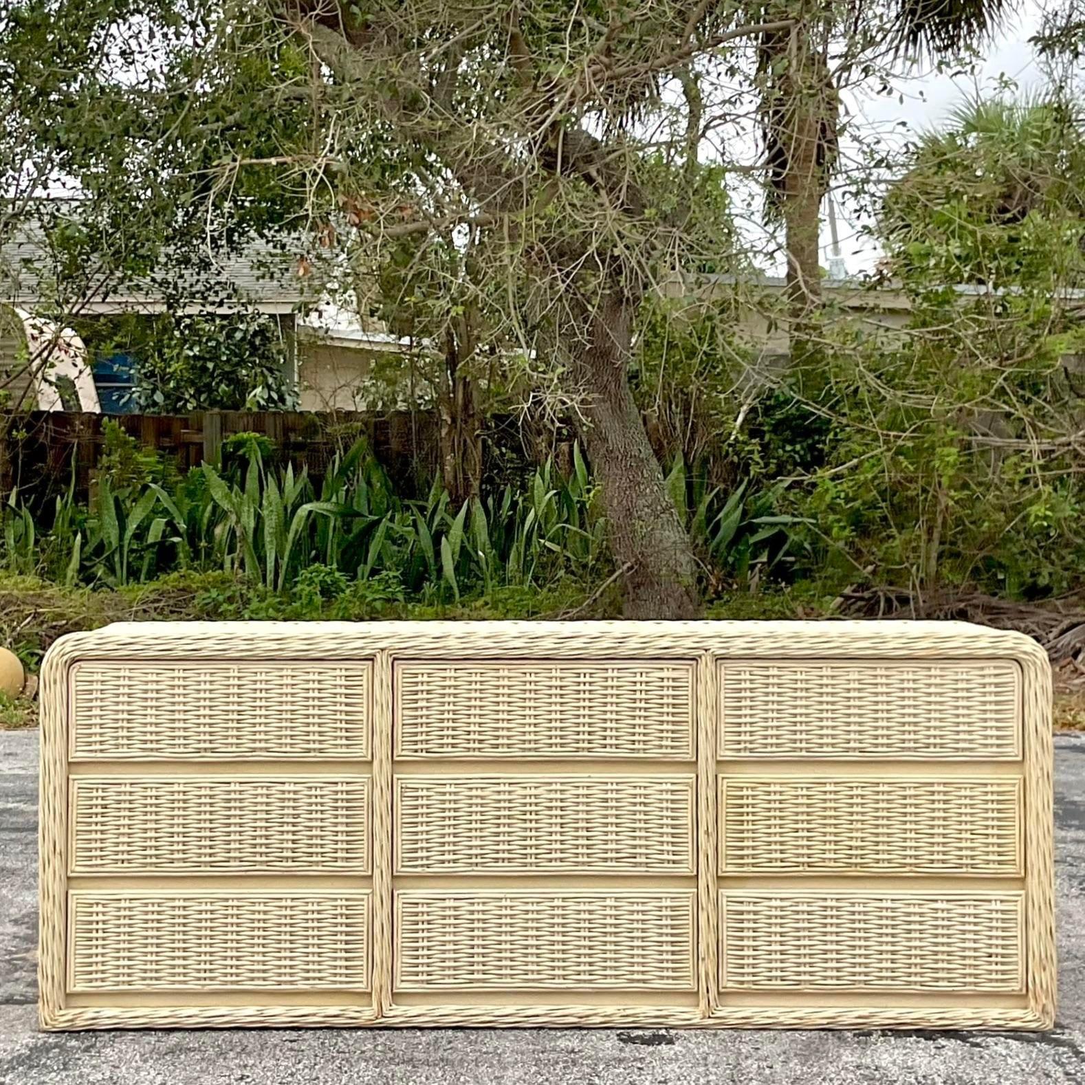 A striking vintage Coastal 9 drawer dresser. Thick woven rattan in a clean waterfall shape. A distressed painted finish with fantastic patina from time. Perfect as a dresser or a chic beach house credenza. Acquired from a Palm Beach estate.