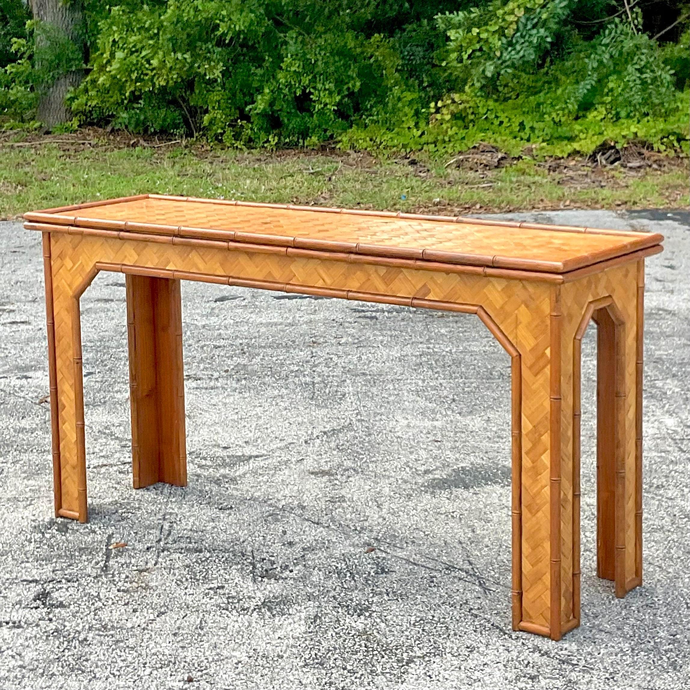 A fantastic vintage Coastal console table. A chic parquet rattan design with solid rattan trim. Coordination side tables also available on my page. Acquired from a Palm Beach estate.