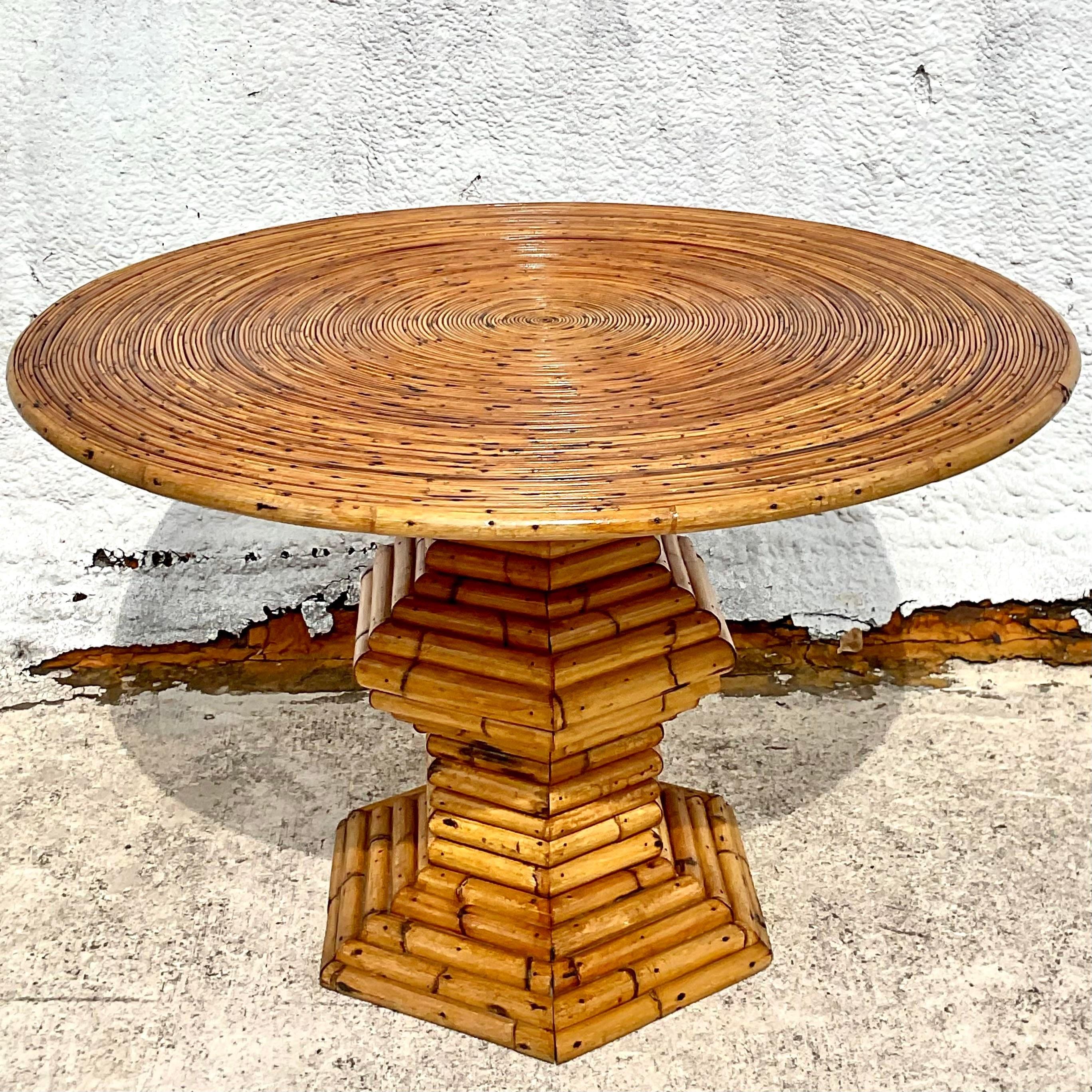 An extraordinary vintage Coastal dining table. A chic coiled pencil reed top that rests on a bamboo angled pedestal. A super special piece. Acquired from a Palm Beach estate.