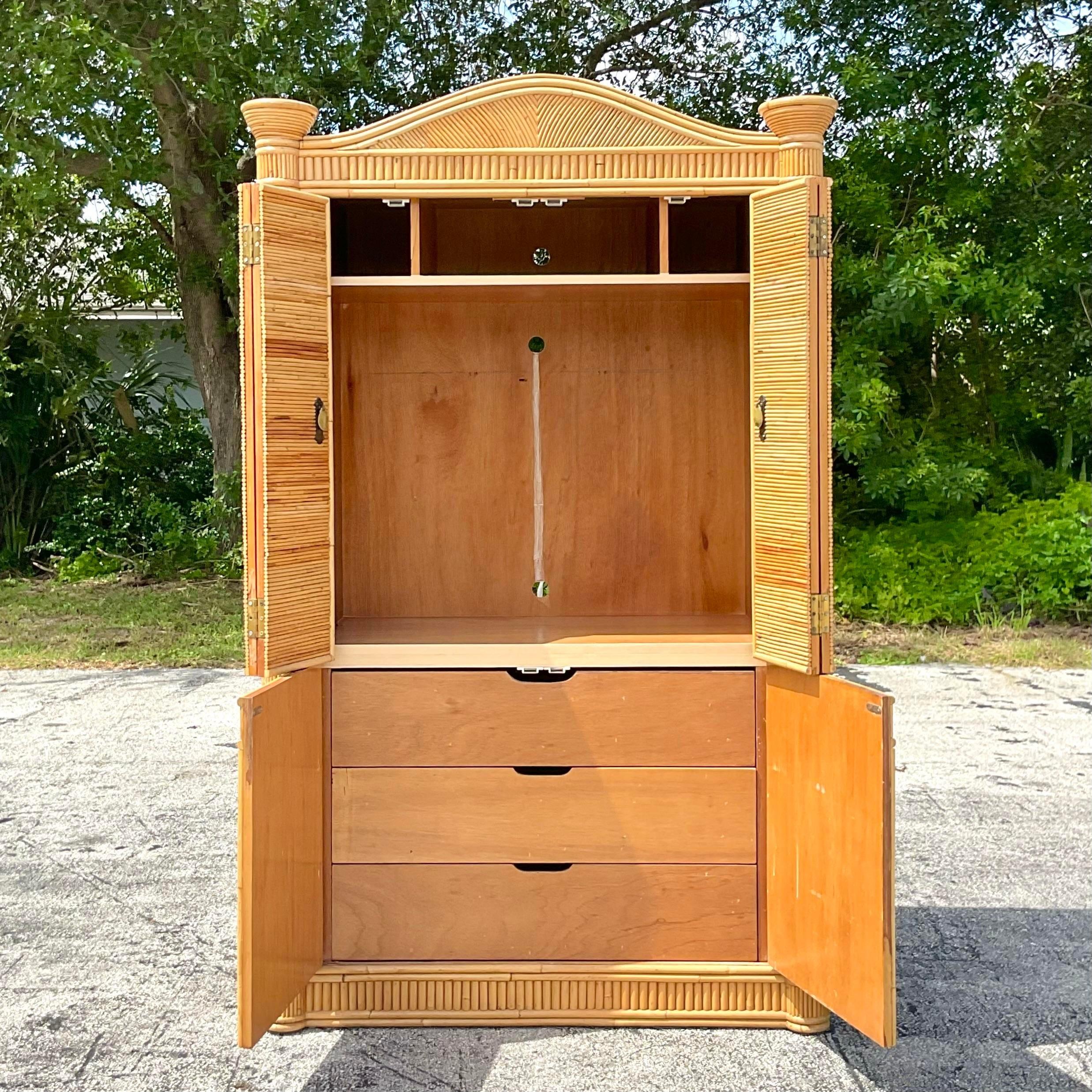  fantastic vintage Coastal armoire. A stunning pencil reed cabinet with an upper and lower space. Currently outfitted to use for a tv with thr holes drilled in the back. Drawers below. Top doors fold back for easy movement. Acquired from a Palm