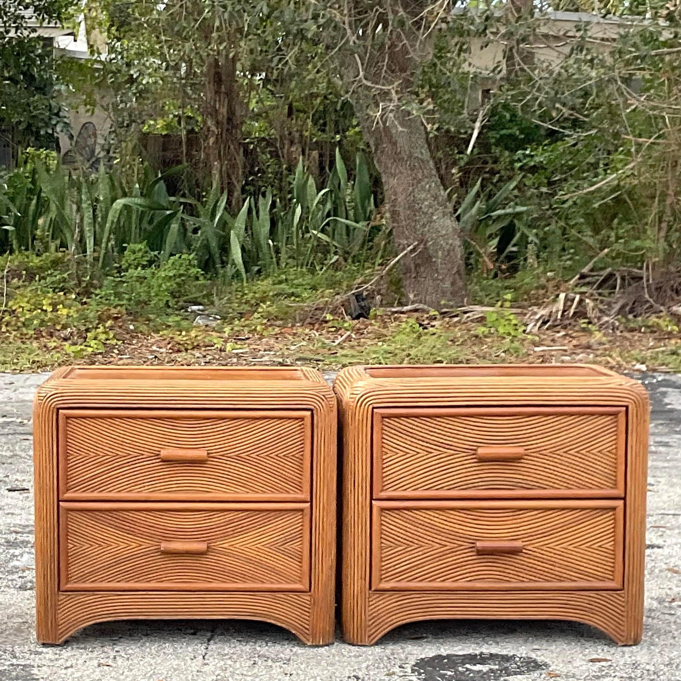 A fabulous pair of vintage Coastal nightstands. A chic pencil reed cabinet in a waterfall shape. Acquired from a Palm Beach estate.