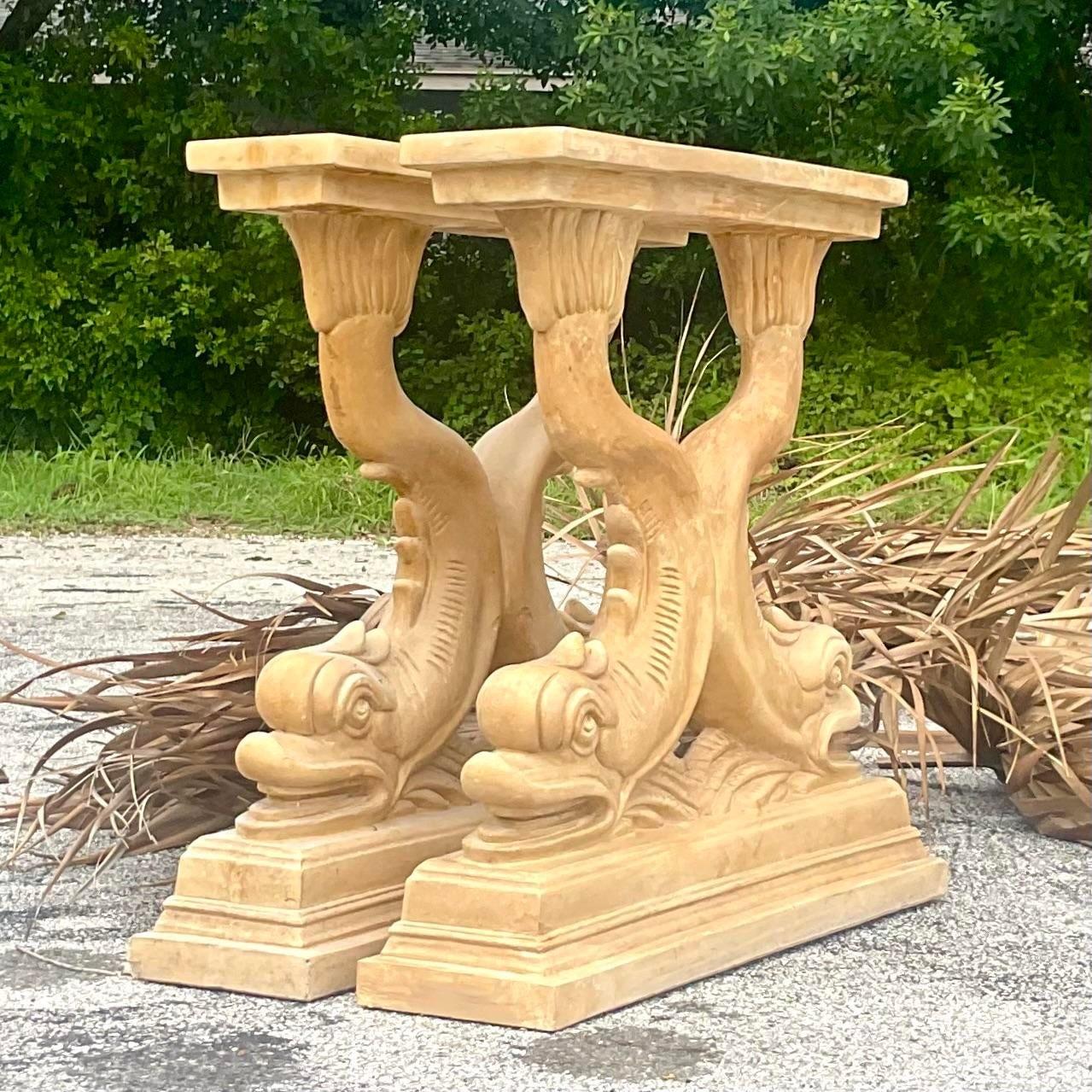 A stunning pair of vintage Plasters pedestals. A chic pair of dolphins in a warm gold color. Just add your favorite glass for a dining table or chic console table. Acquired from a Palm Beach estate.