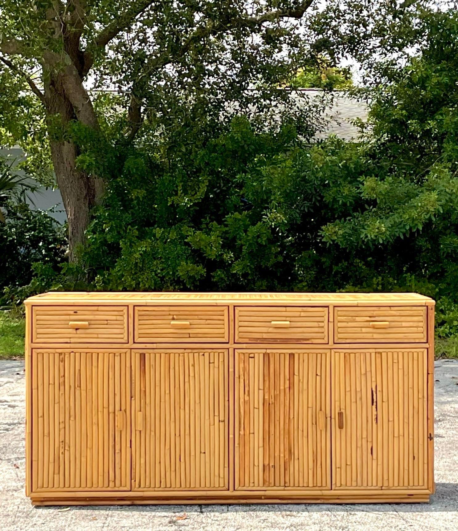 A fabulous vintage Coastal four door credenza. A chic vertical rattan design in a clean and modern design. Acquired from a Palm Beach estate.
