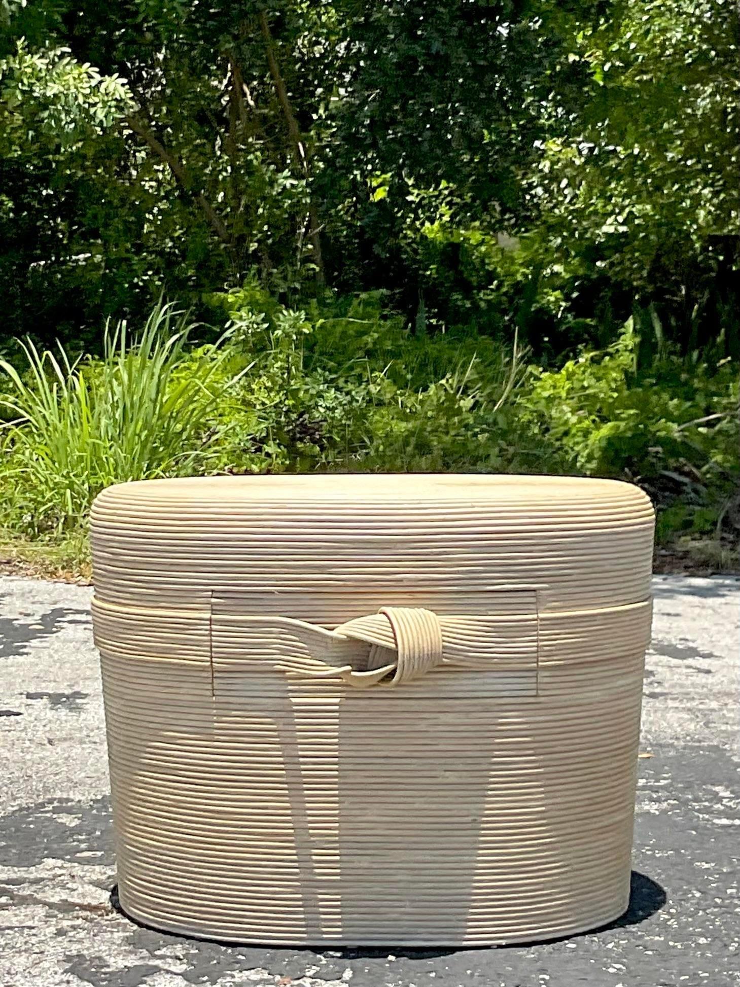 A fabulous vintage Coastal Side table. Done in the manner of Betty Cobonpue. A chic cerused pencil reed with the coveted Ribbon knot detail. Acquired from a Palm Beach estate.
