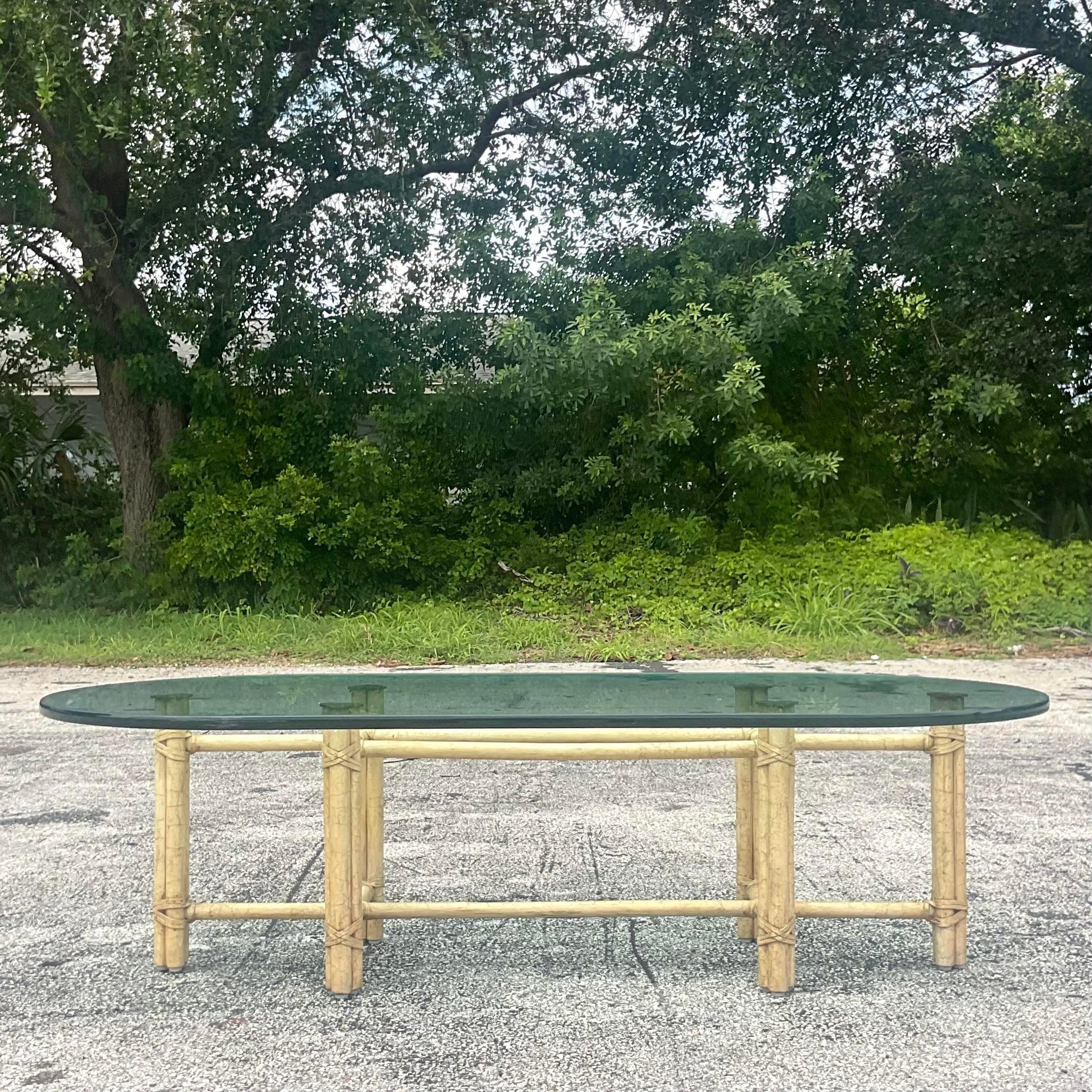 A fabulous vintage Coastal coffee table. Made by the iconic McGuire group and tagged on the bottom. Classic McGuire rattan shape with a thick glass top. Acquired from a Palm Beach estate. 